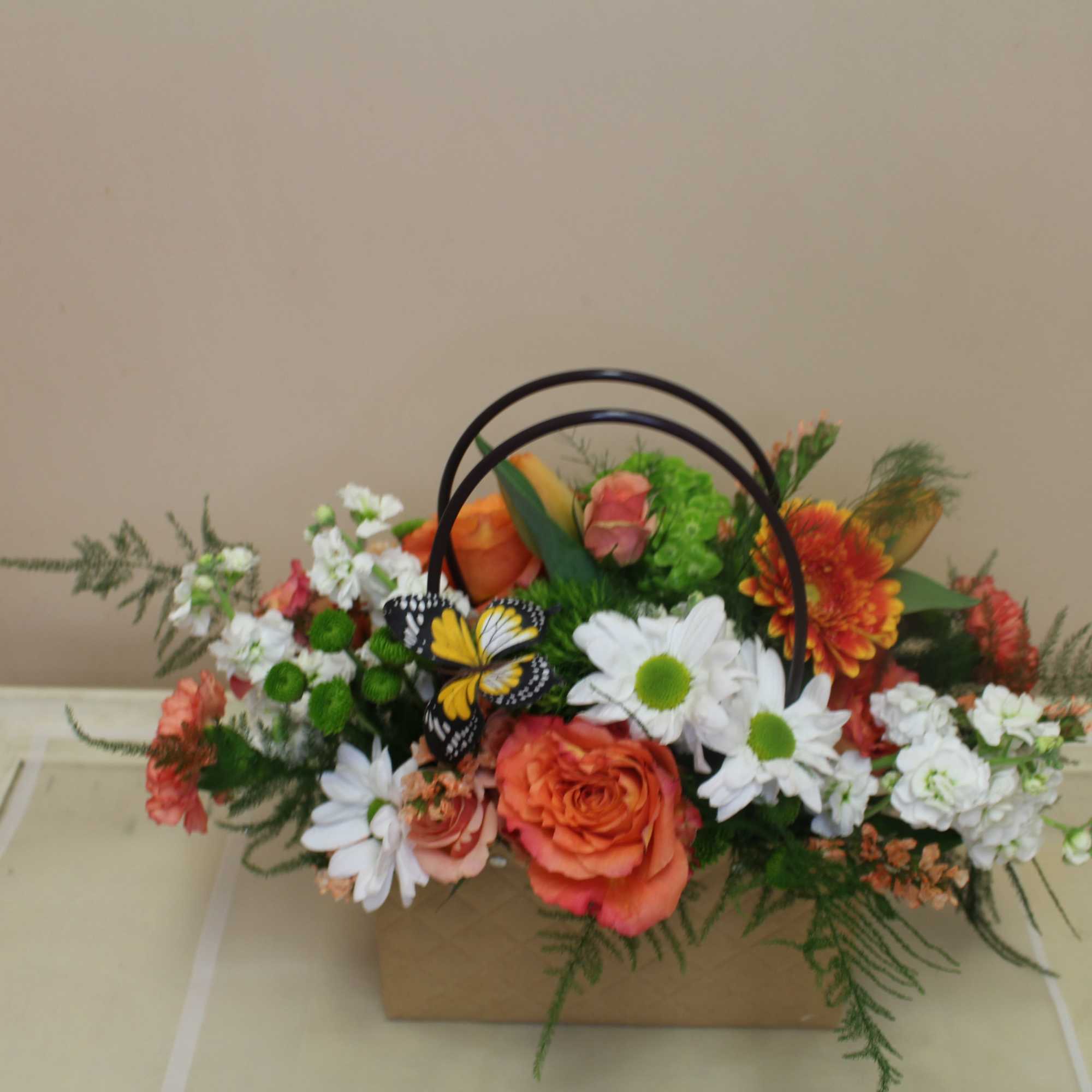 Bright orange roses paired with cheerful white daisies and carnations give this