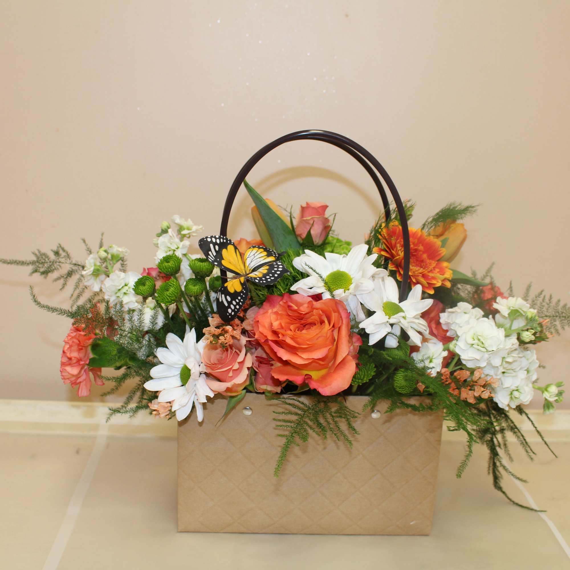 Bright orange roses paired with cheerful white daisies and carnations give this