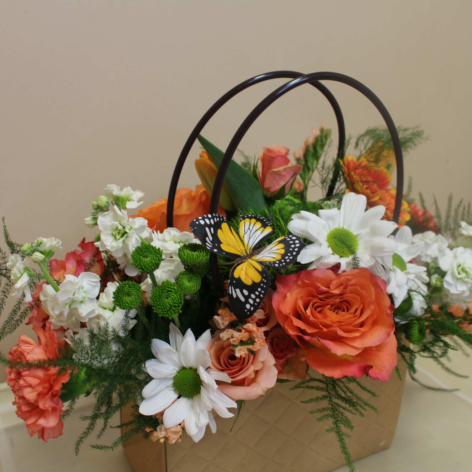Bright orange roses paired with cheerful white daisies and carnations give this