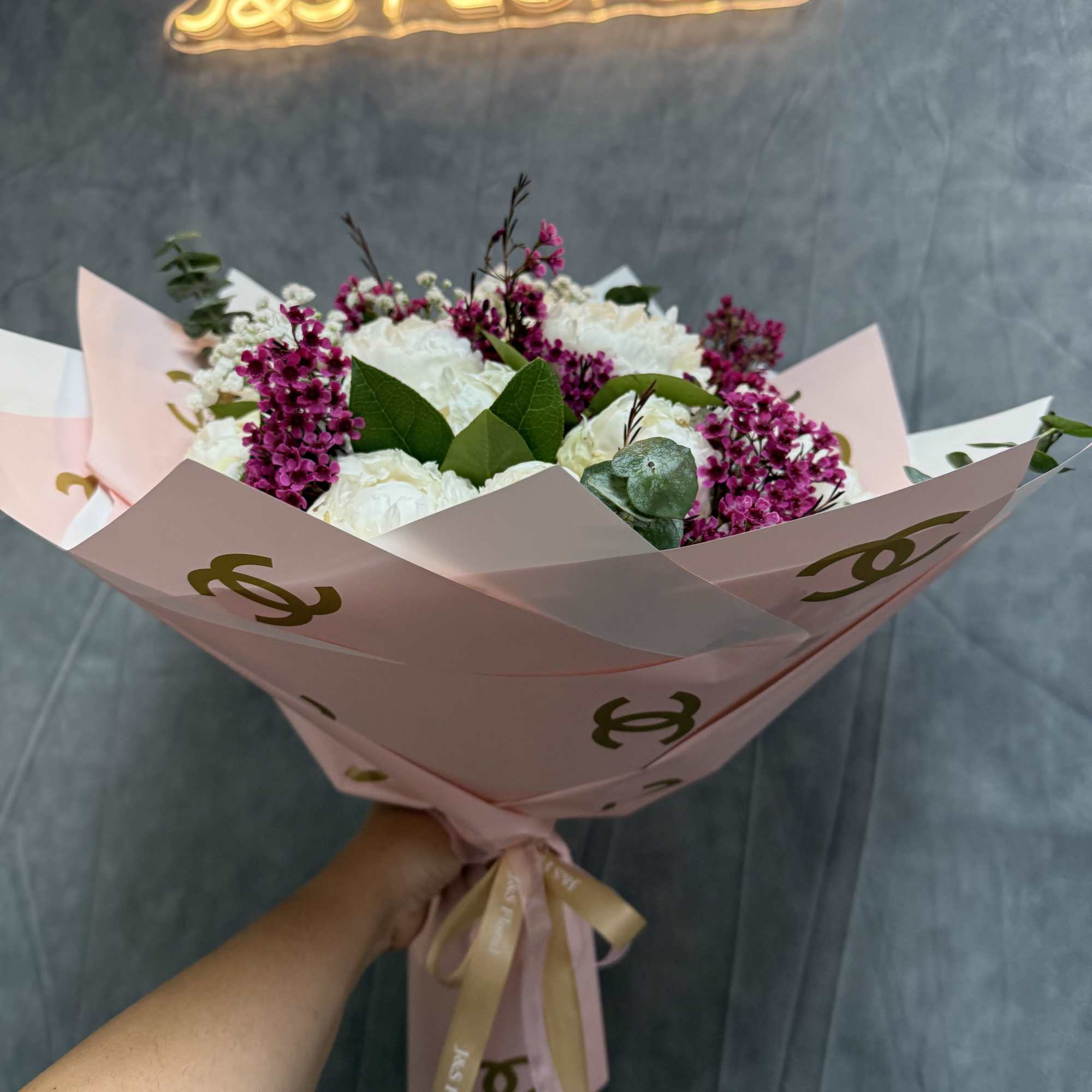 Pink and white bouquet wrapped in pastel paper with a ribbon