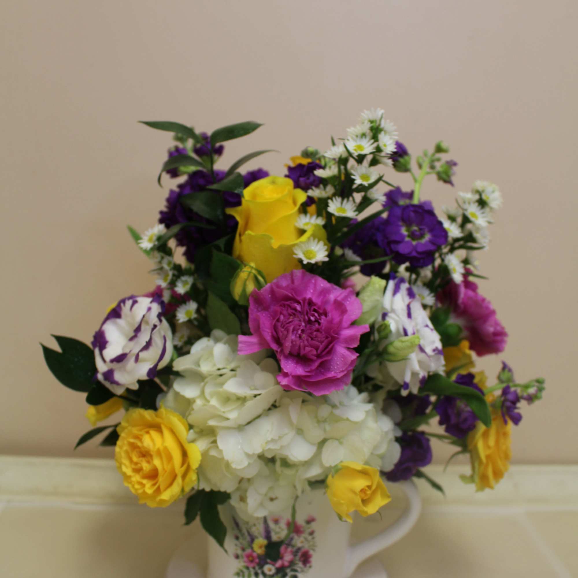A bright, playful floral arrangement presented in a ceramic mug and saucer