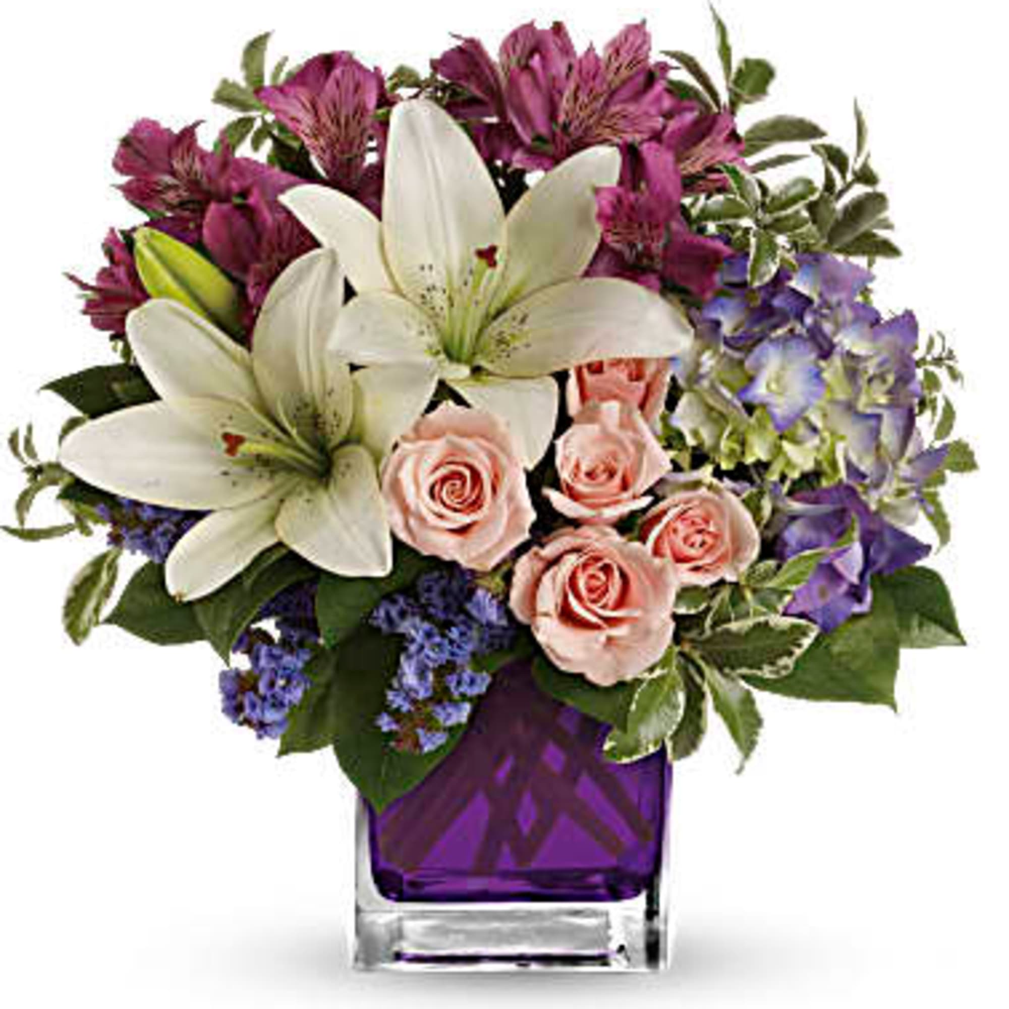 Bouquet of white lilies, pink roses, and purple flowers in a purple vase