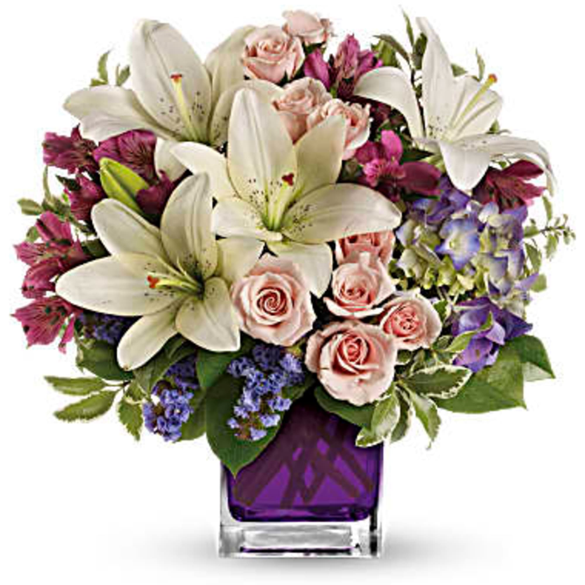Bouquet of white lilies, pink roses, and purple flowers in a purple glass vase
