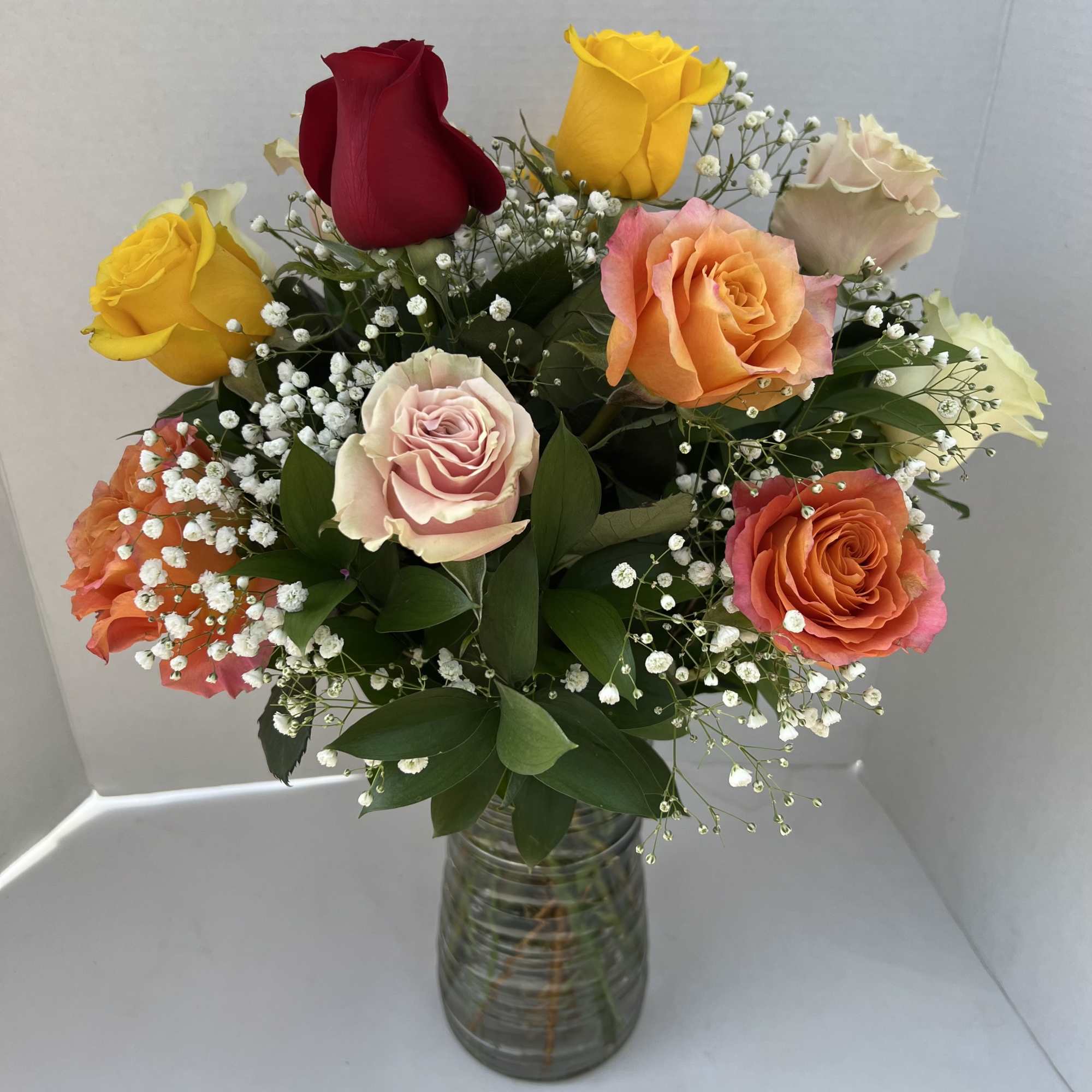 The roses are artfully arranged in a classic vase and accented with