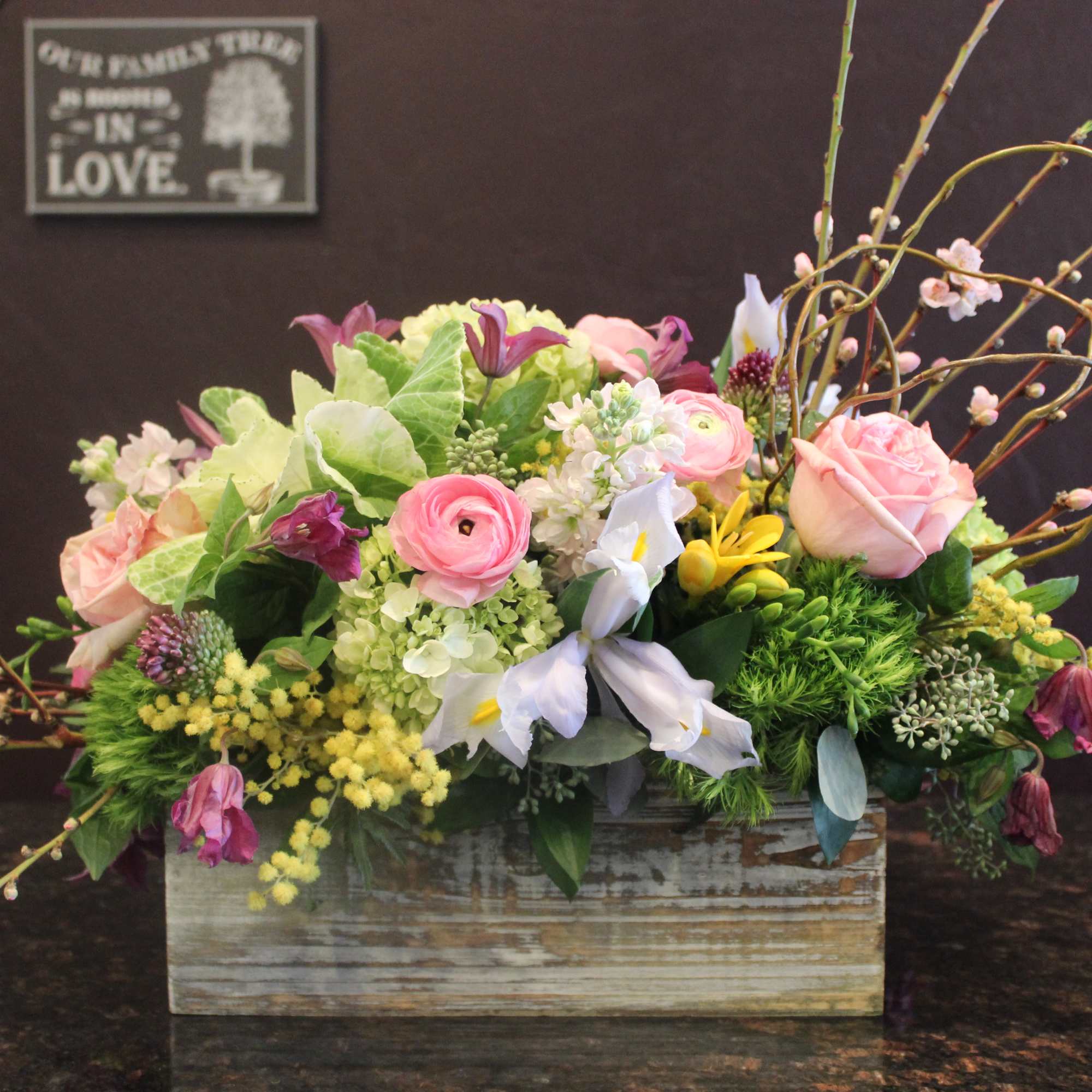 Mixed pink and white flowers arranged in a rustic wooden box
