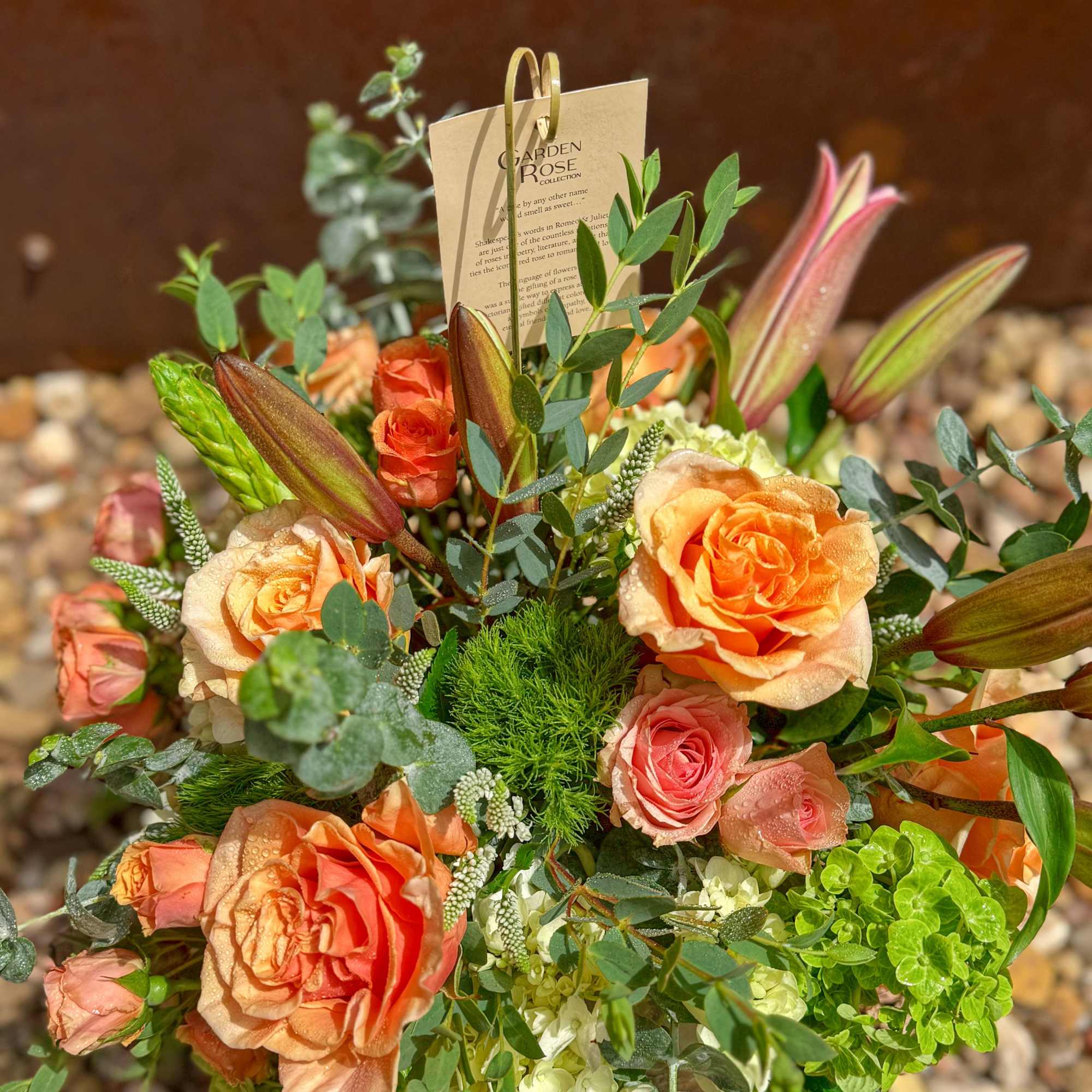 Peach and pink rose bouquet with lilies and greenery