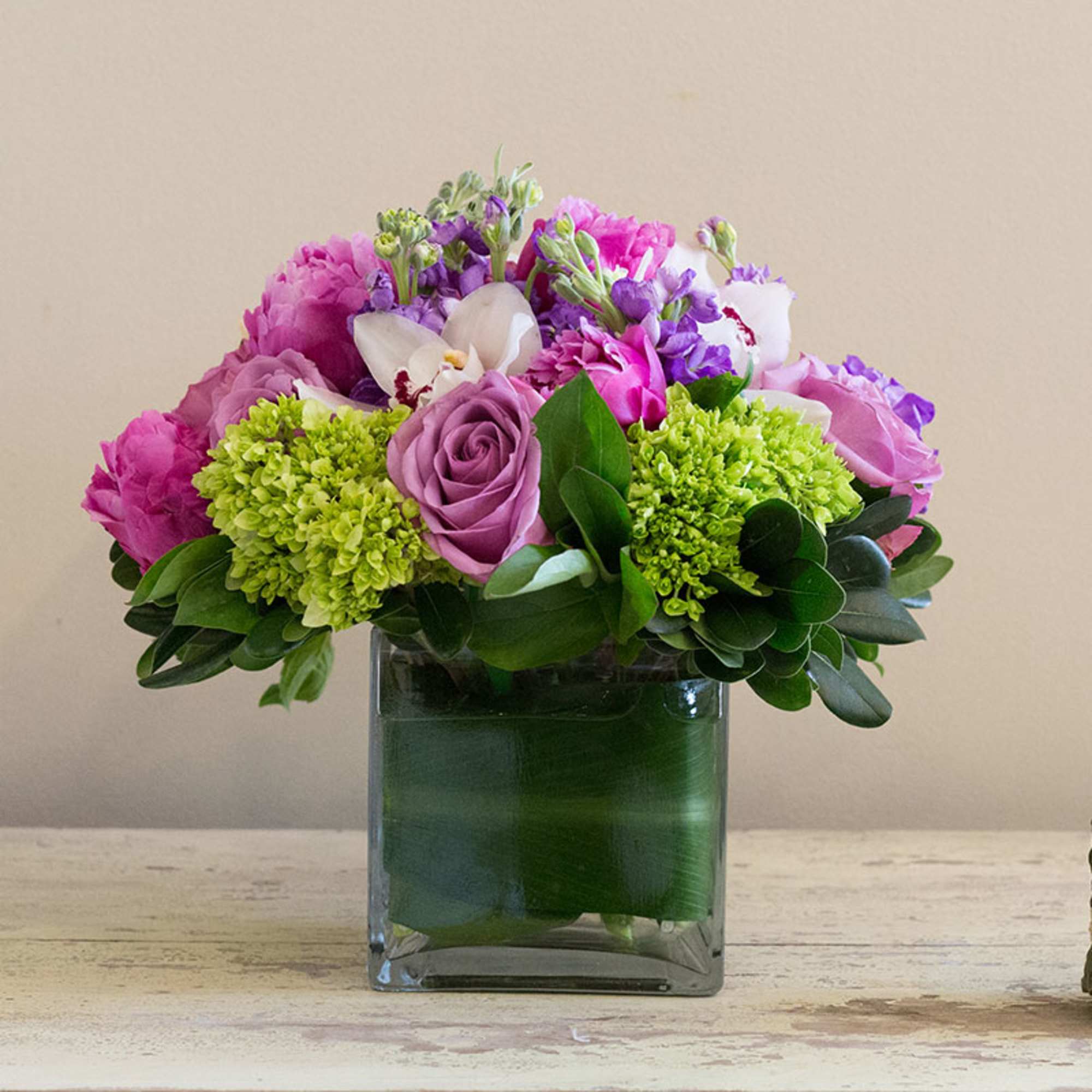 A lush arrangement of roses, hydrangeas, orchids and peonies