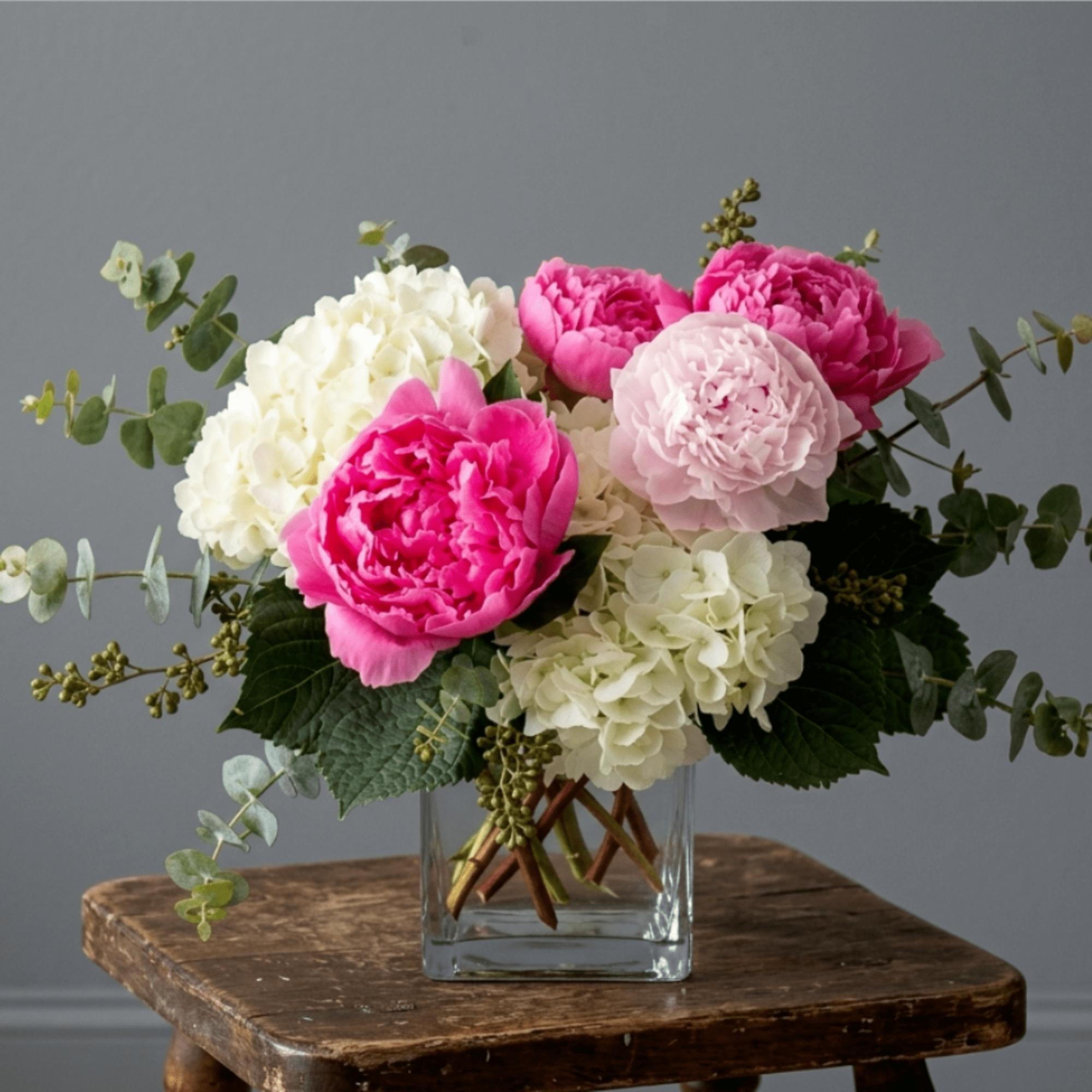a mixture Hot‑pink or light‑pink peonies mixed with creamy hydrangeas, blush accents