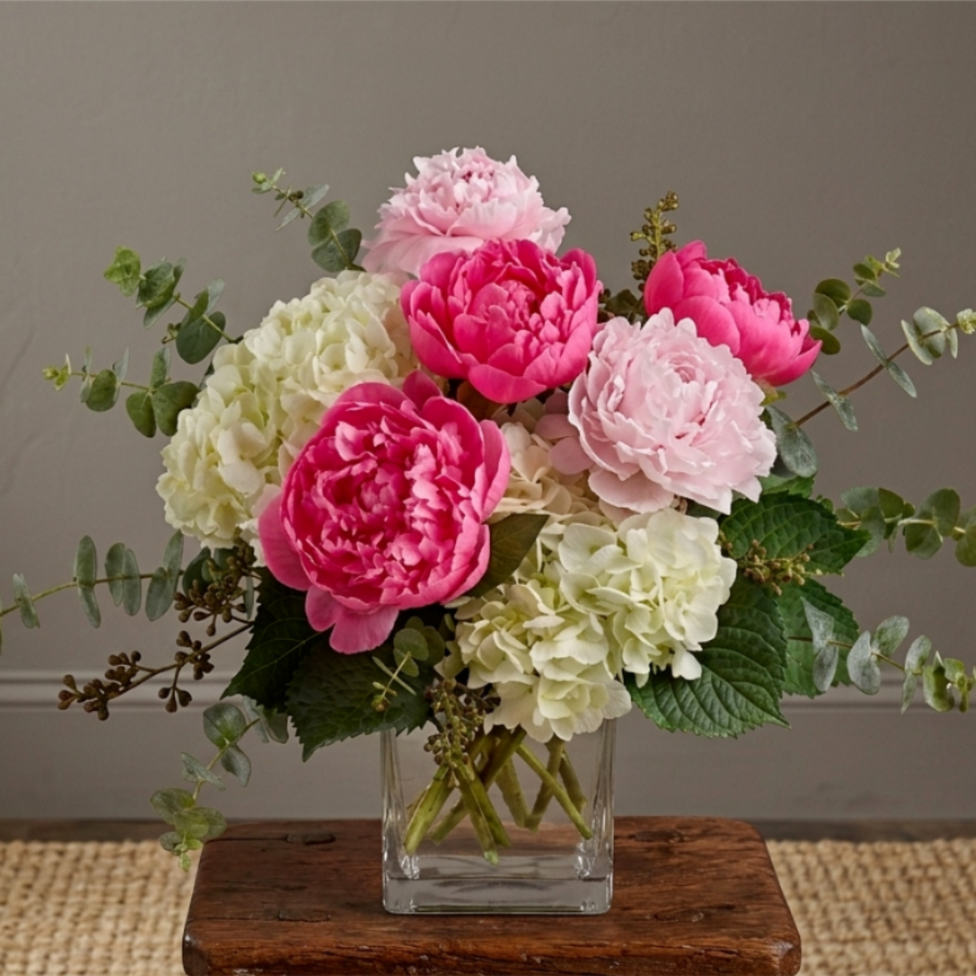 a mixture Hot‑pink or light‑pink peonies mixed with creamy hydrangeas, blush accents