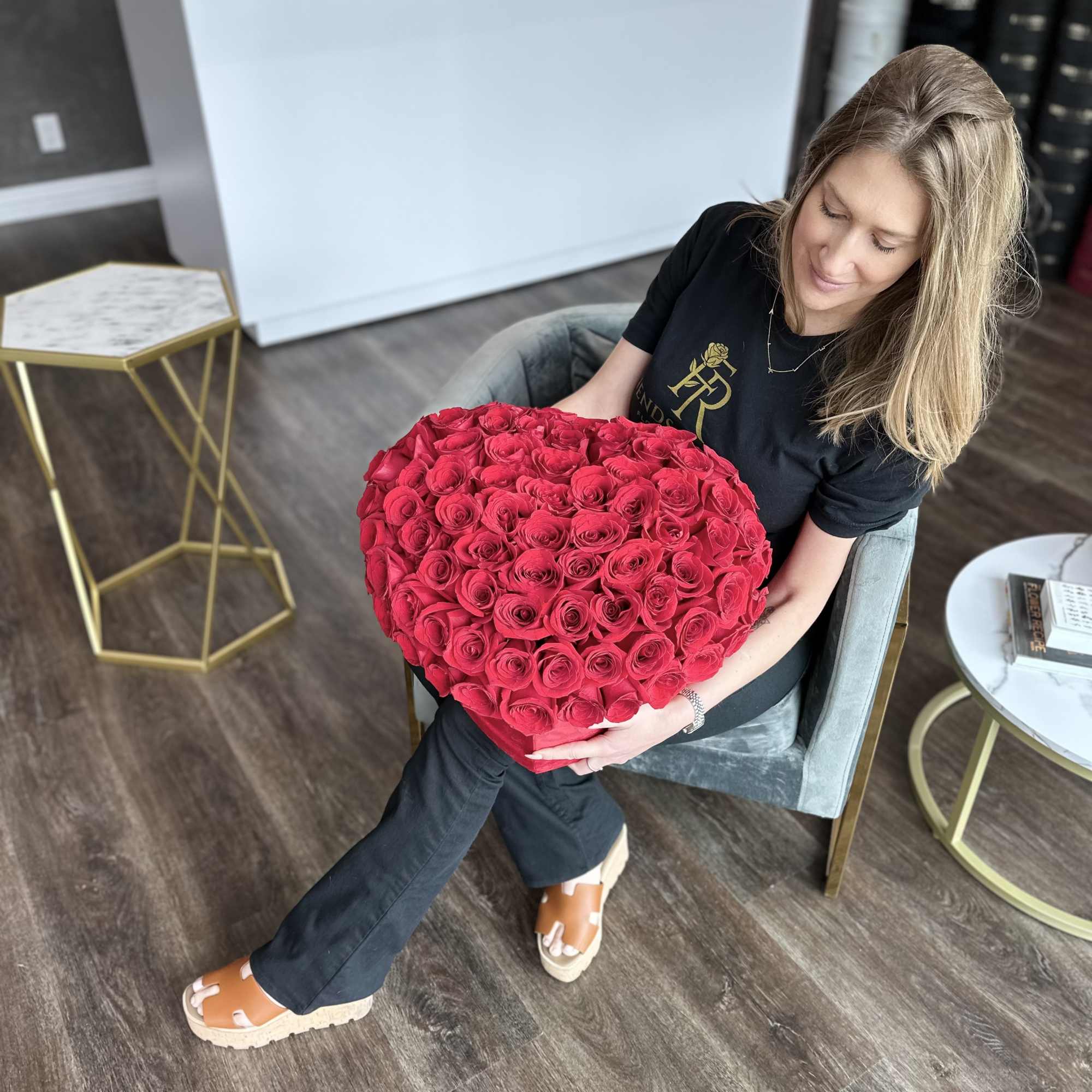 Woman holding a large heart-shaped bouquet of red roses