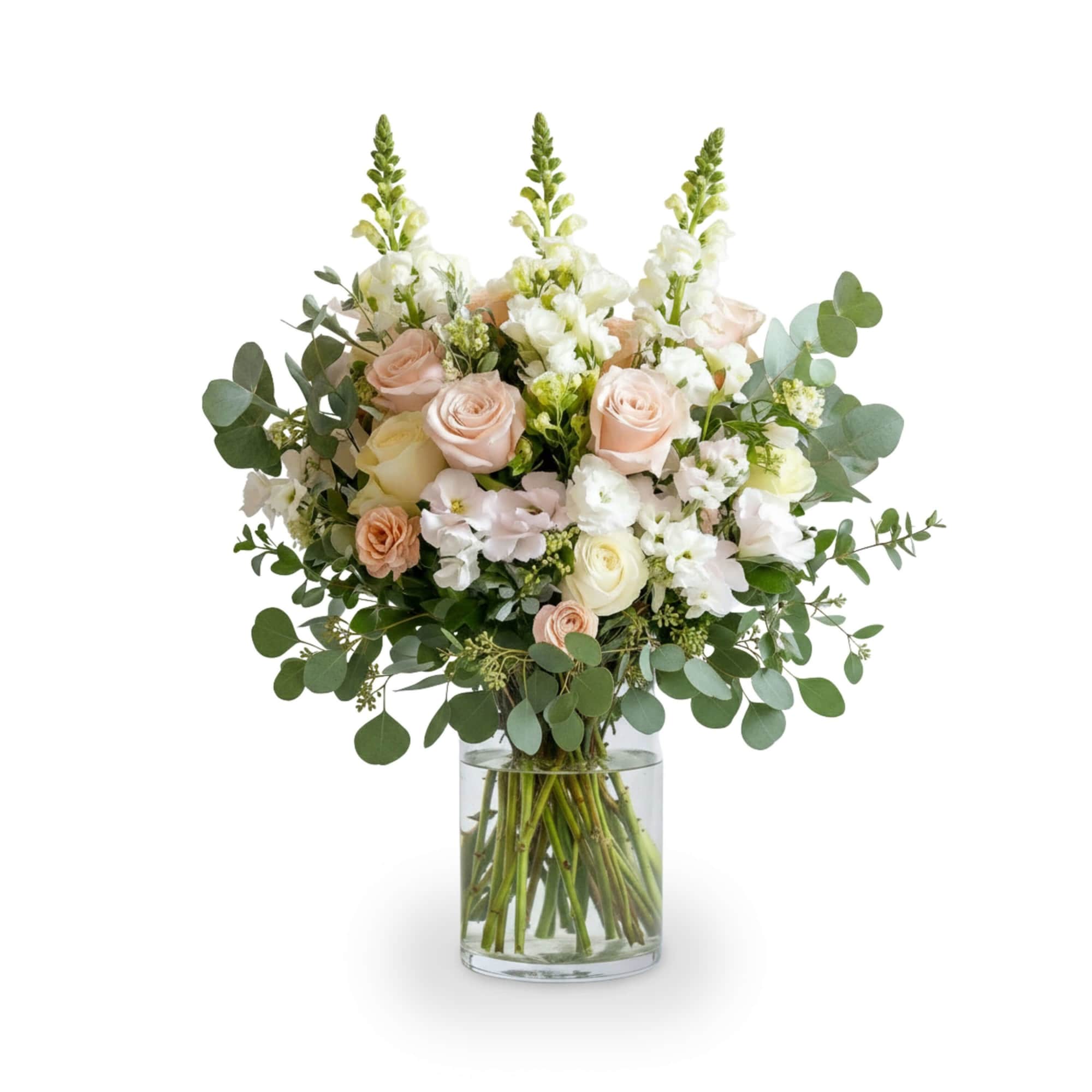 Blush roses and white flowers in a clear glass vase