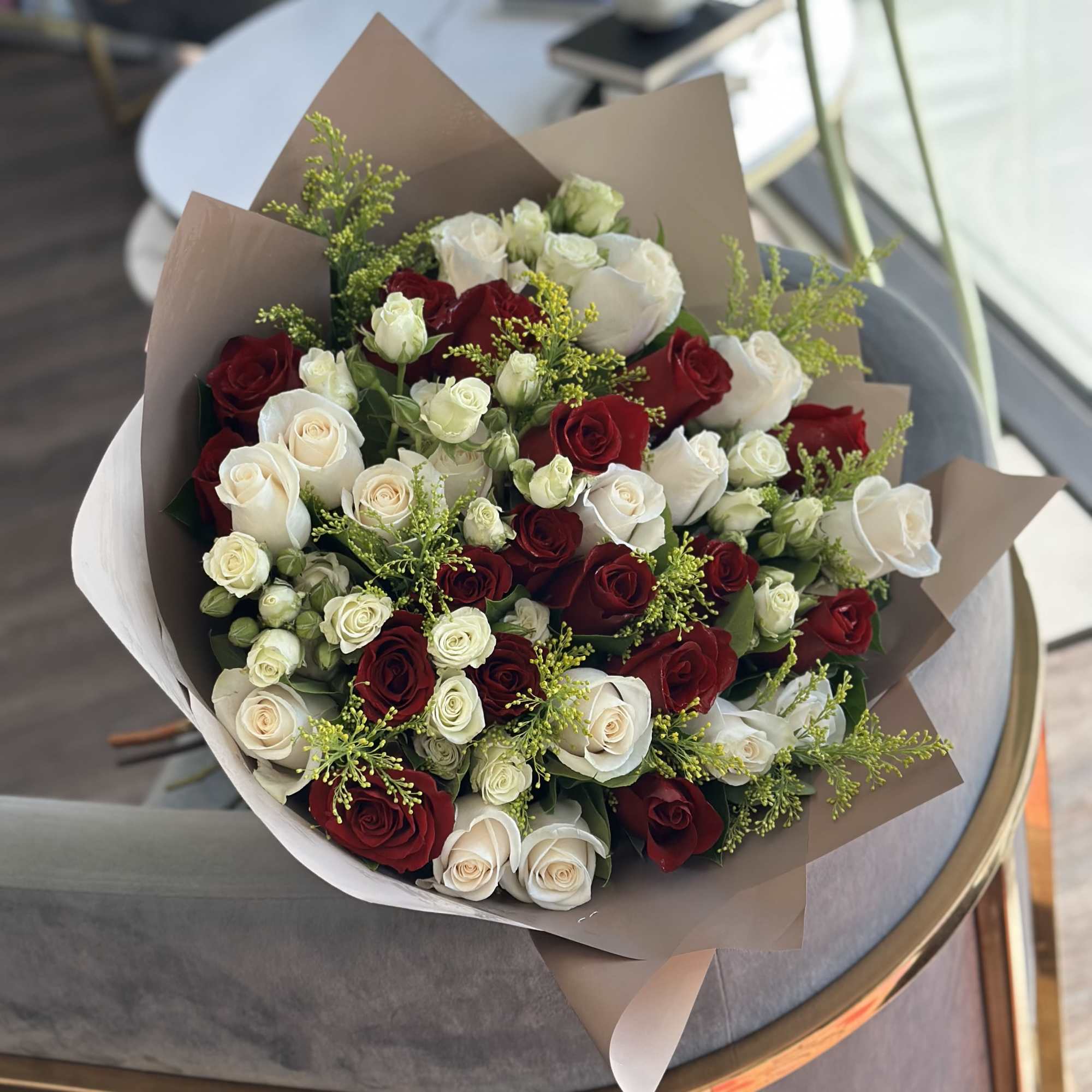 Bouquet of red and white roses wrapped in brown paper