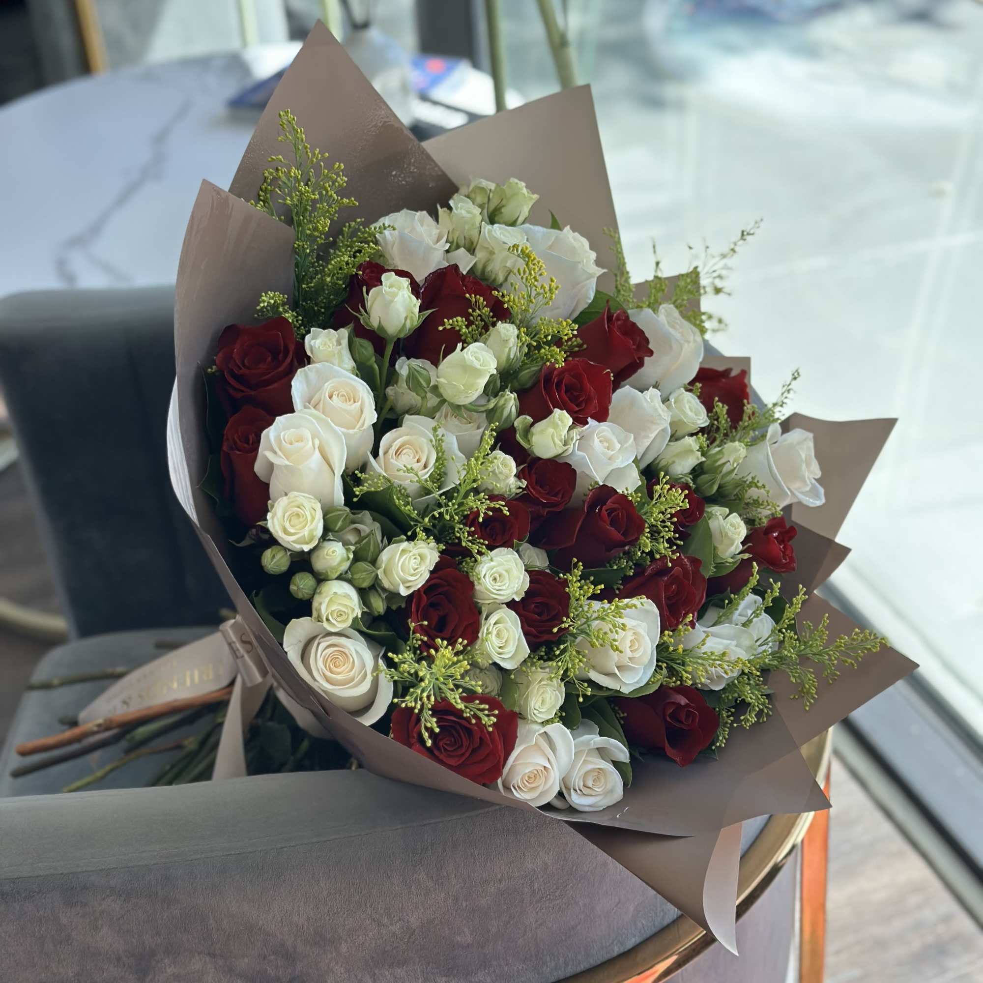 Bouquet of red and white roses wrapped in brown paper