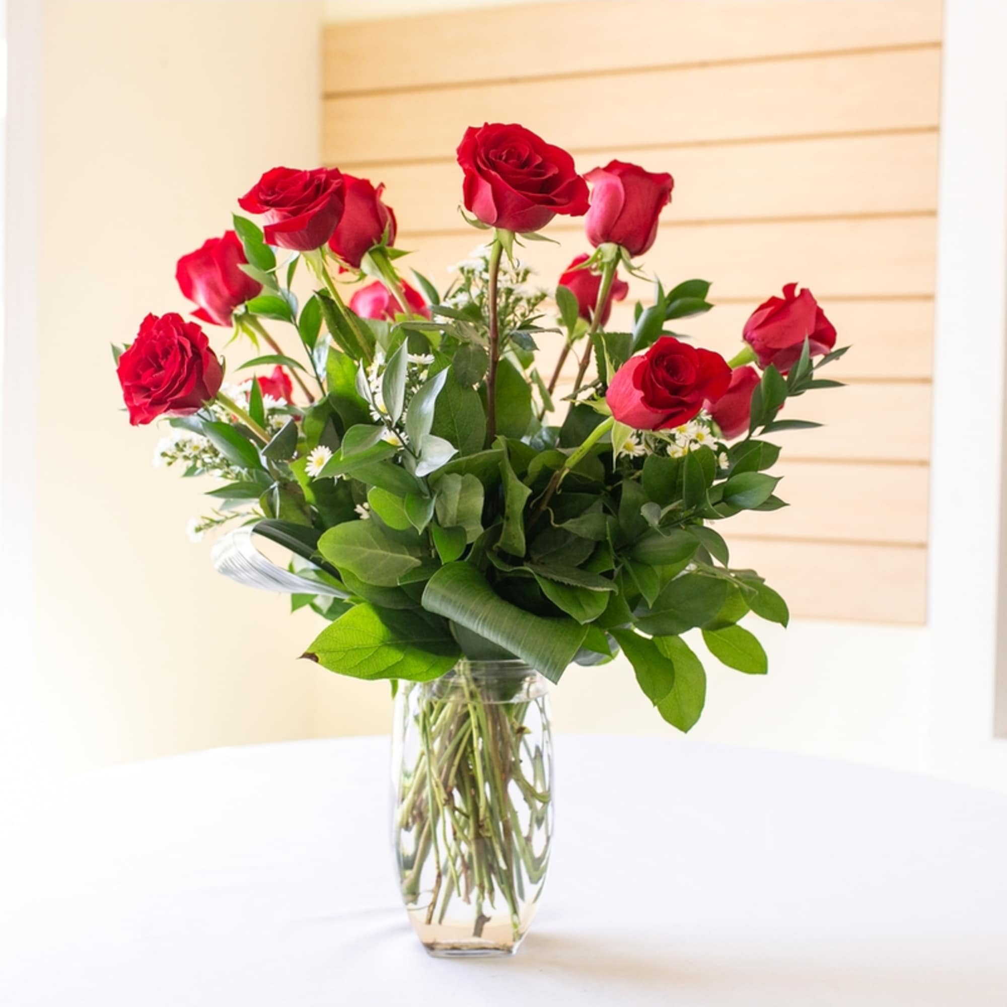 Red roses arranged in a clear glass vase