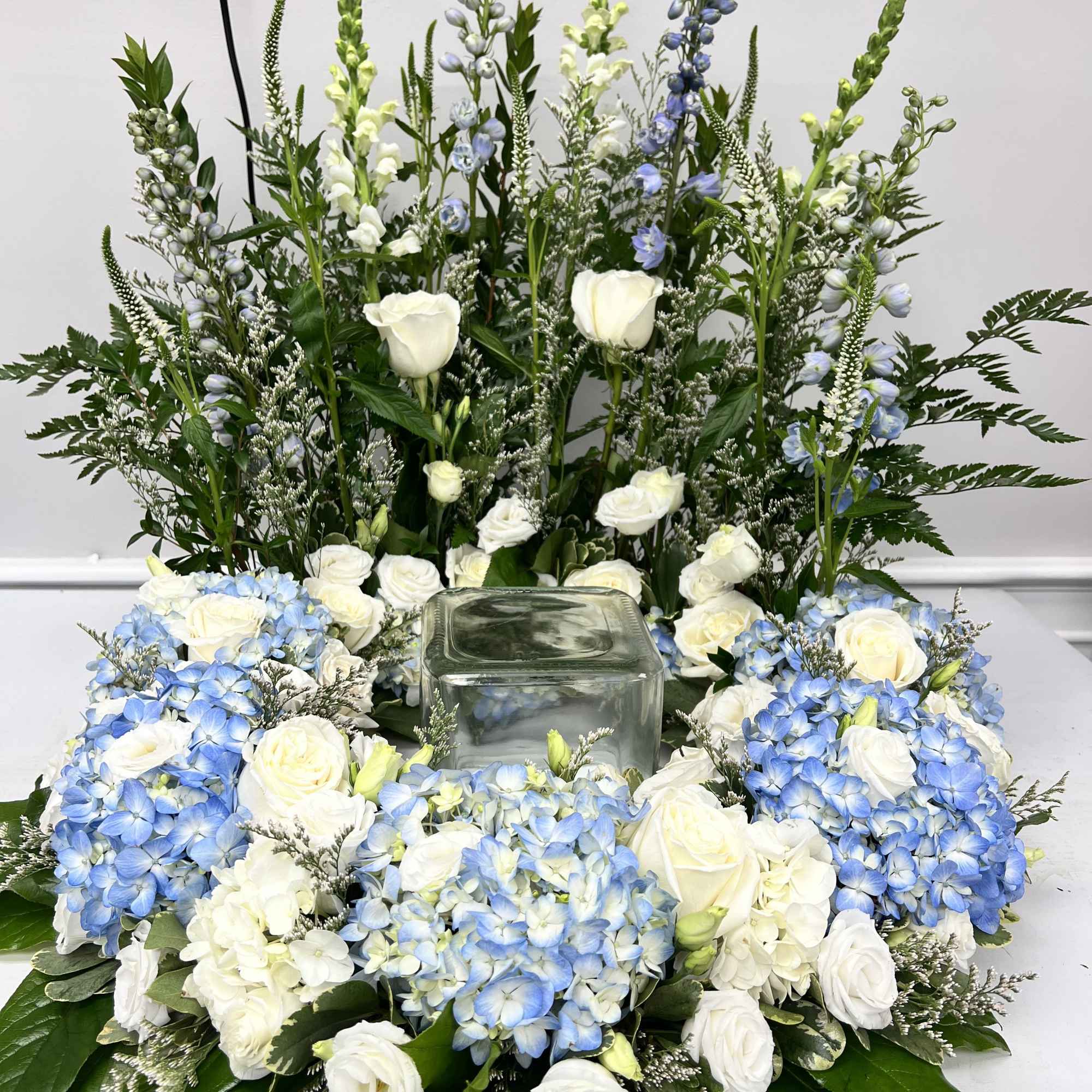 This arrangement surrounds the urn of your loved one with beautiful seasonal