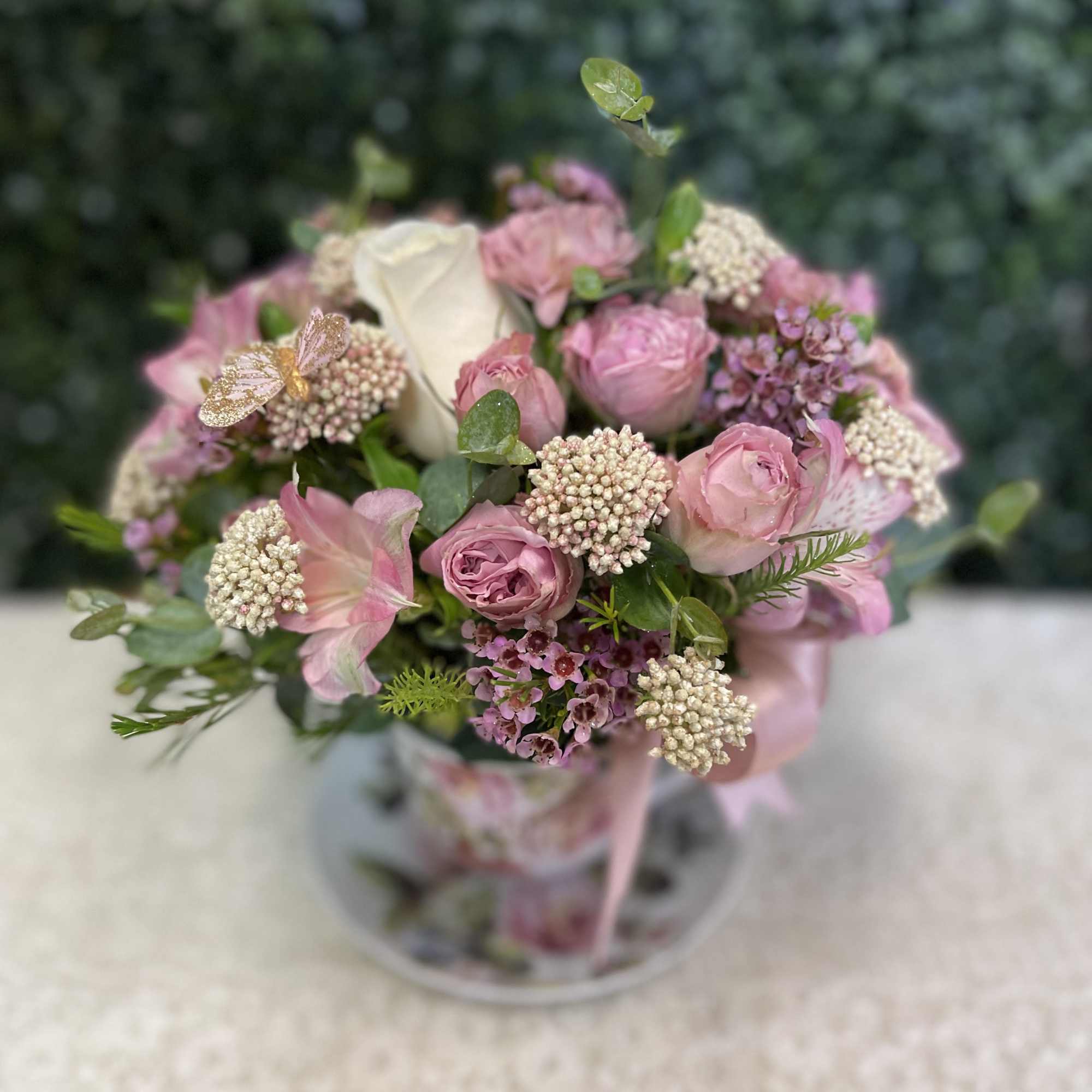 Pink and white bouquet with roses in a clear vase