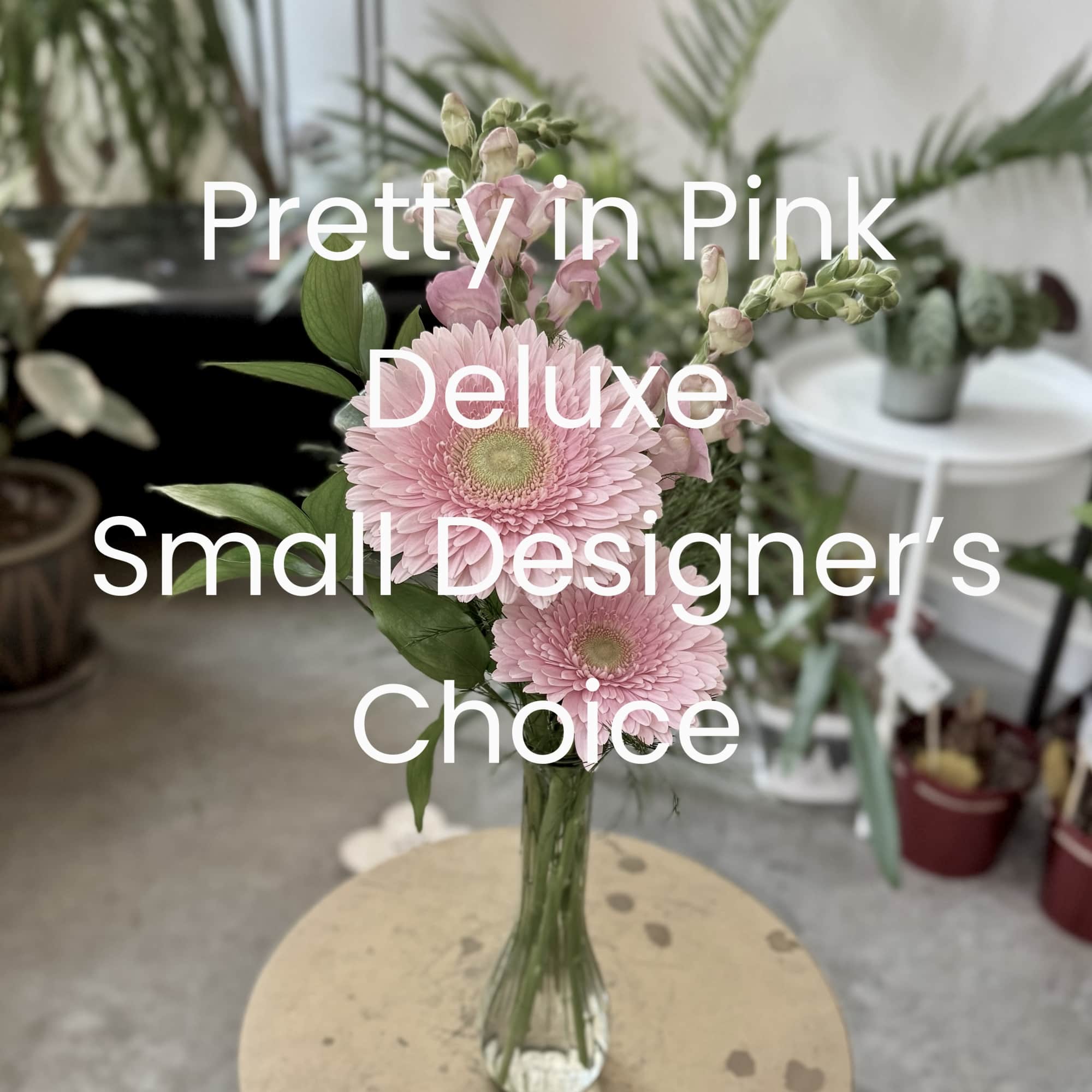 Pink gerbera daisies and snapdragons in a clear glass vase