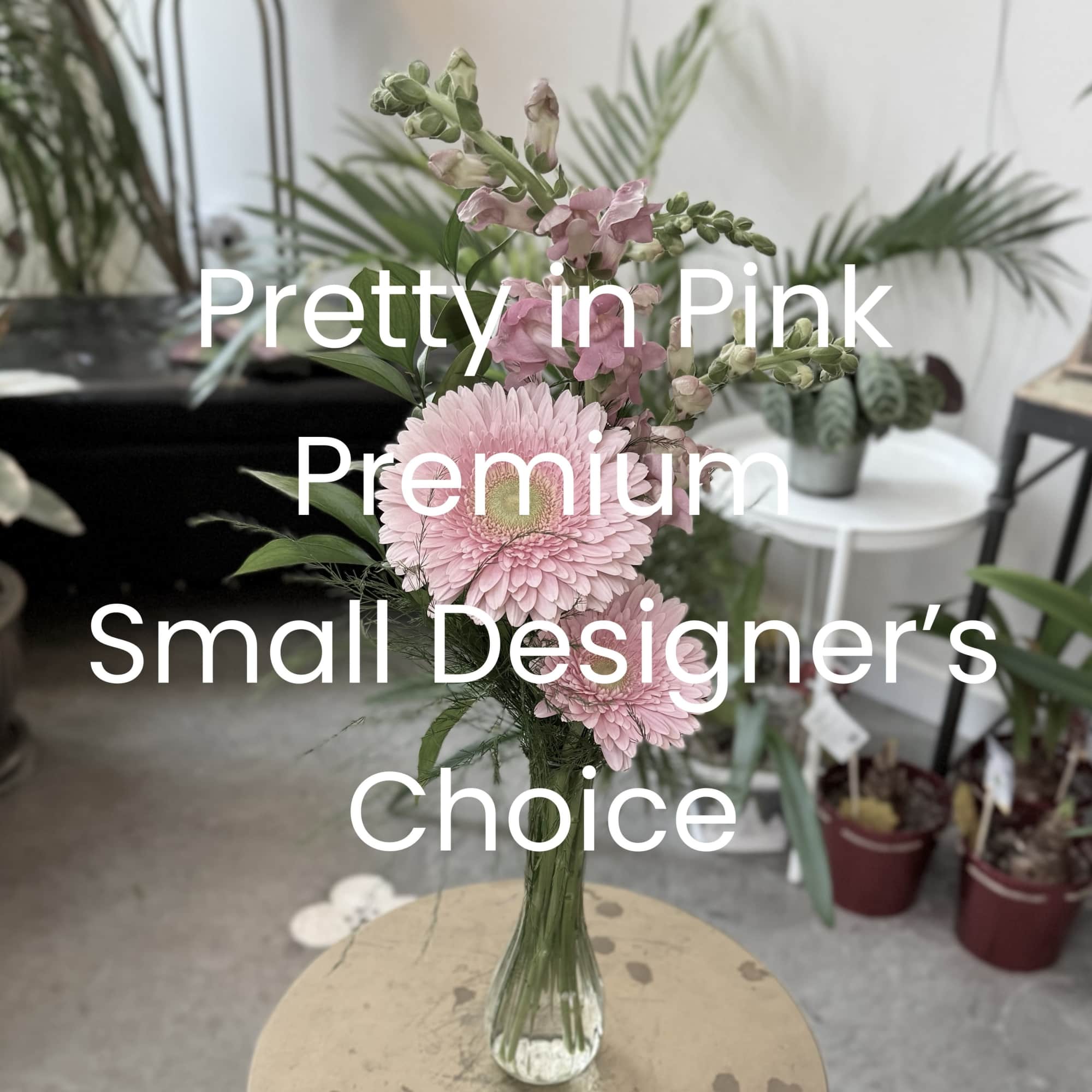 Pink gerbera daisies and snapdragons in a clear glass vase