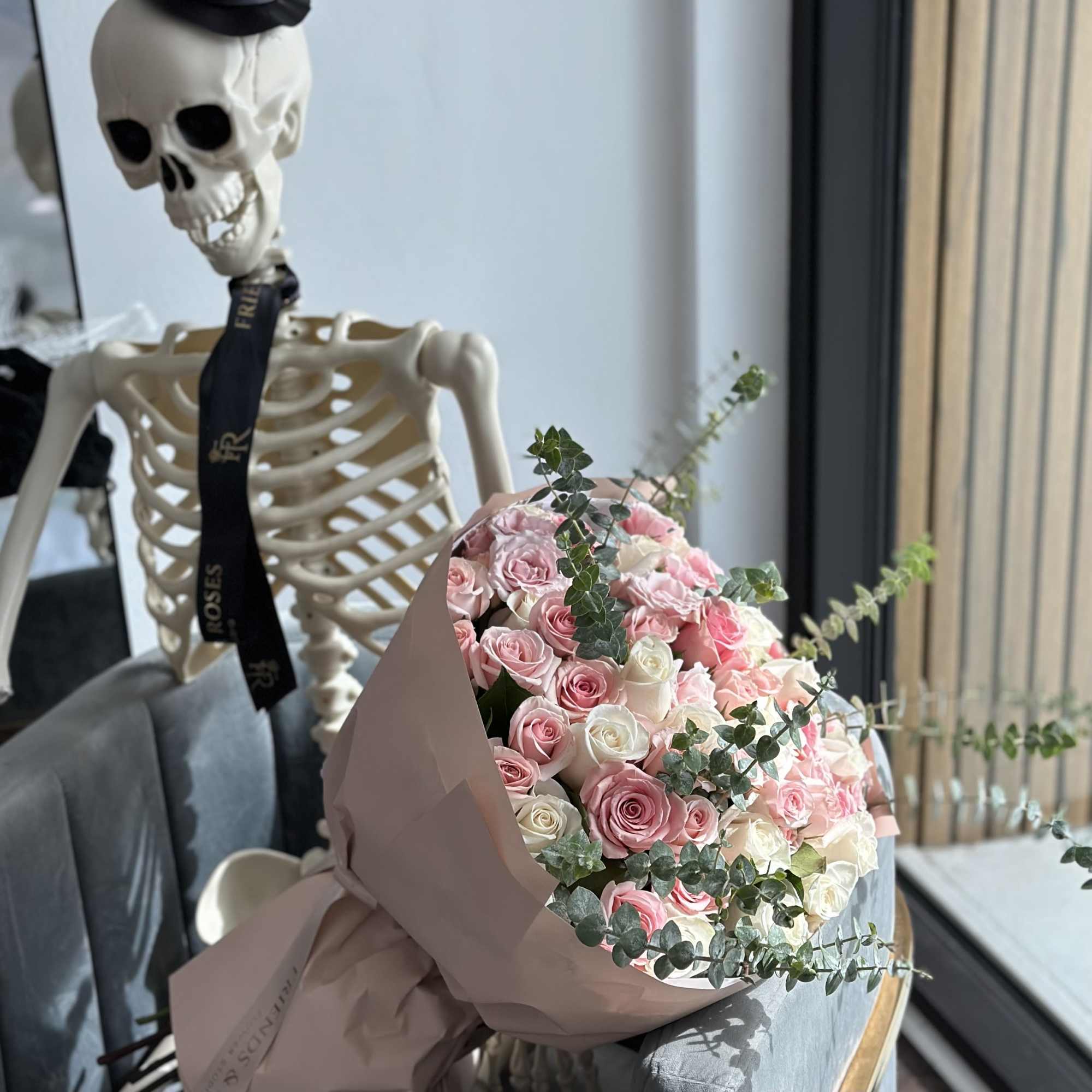 Bouquet of pink and white roses wrapped in blush paper