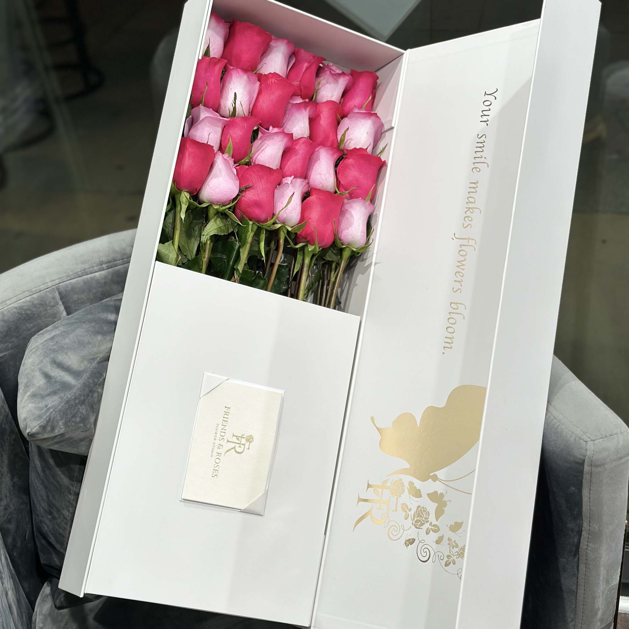 Box of pink and white roses with a small card
