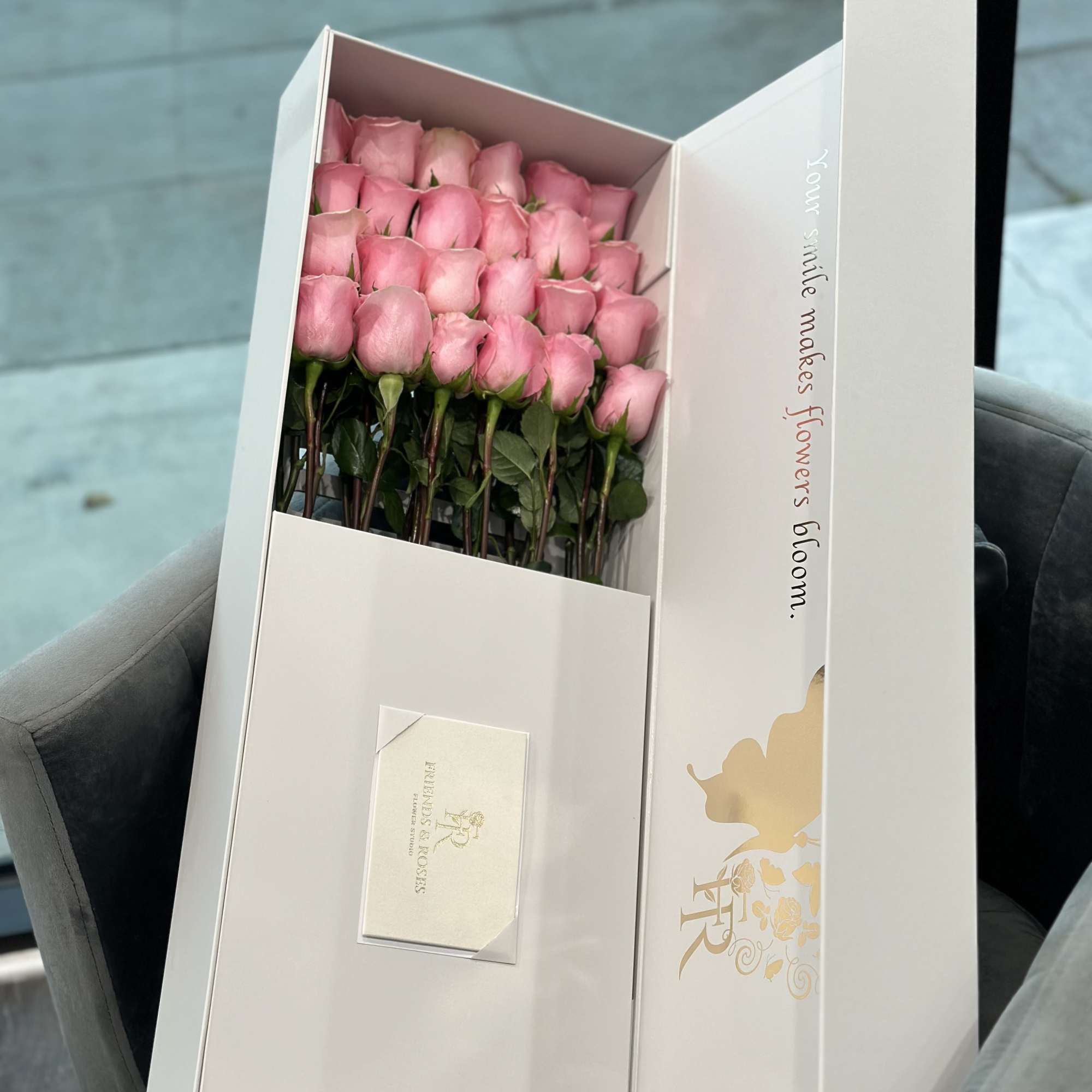 Boxed bouquet of pink roses with a card inside