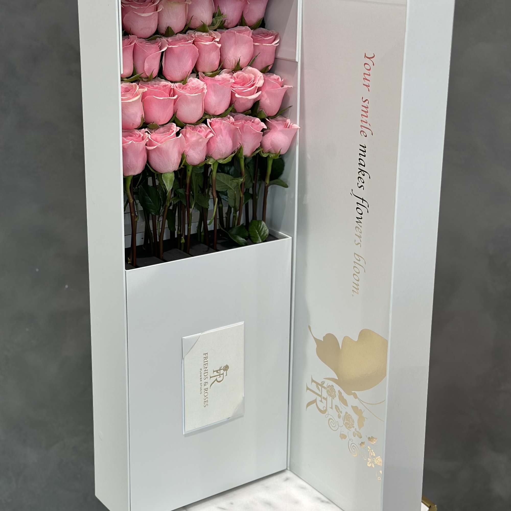 Boxed arrangement of pink roses in a white presentation box