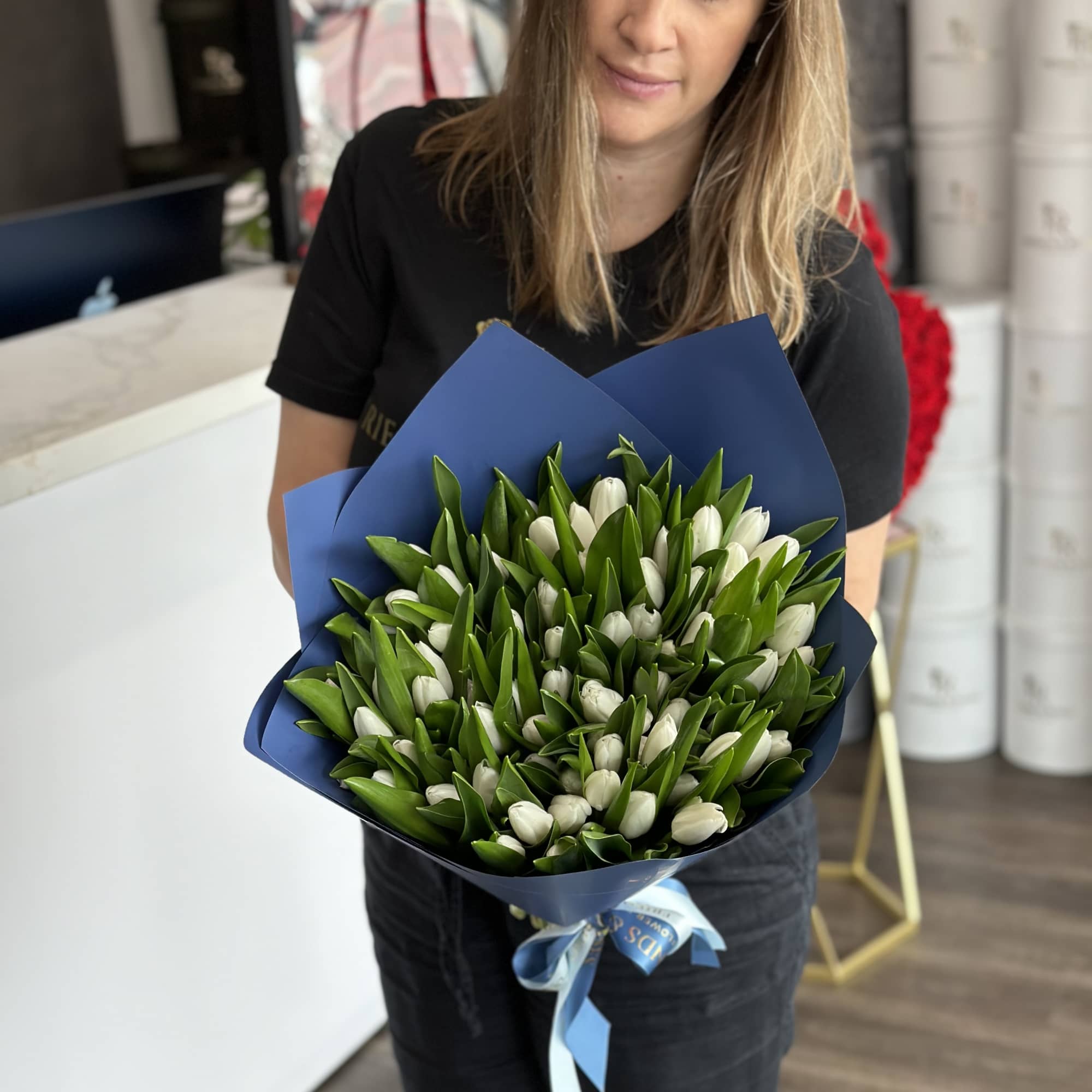Bouquet of white tulips wrapped in blue paper