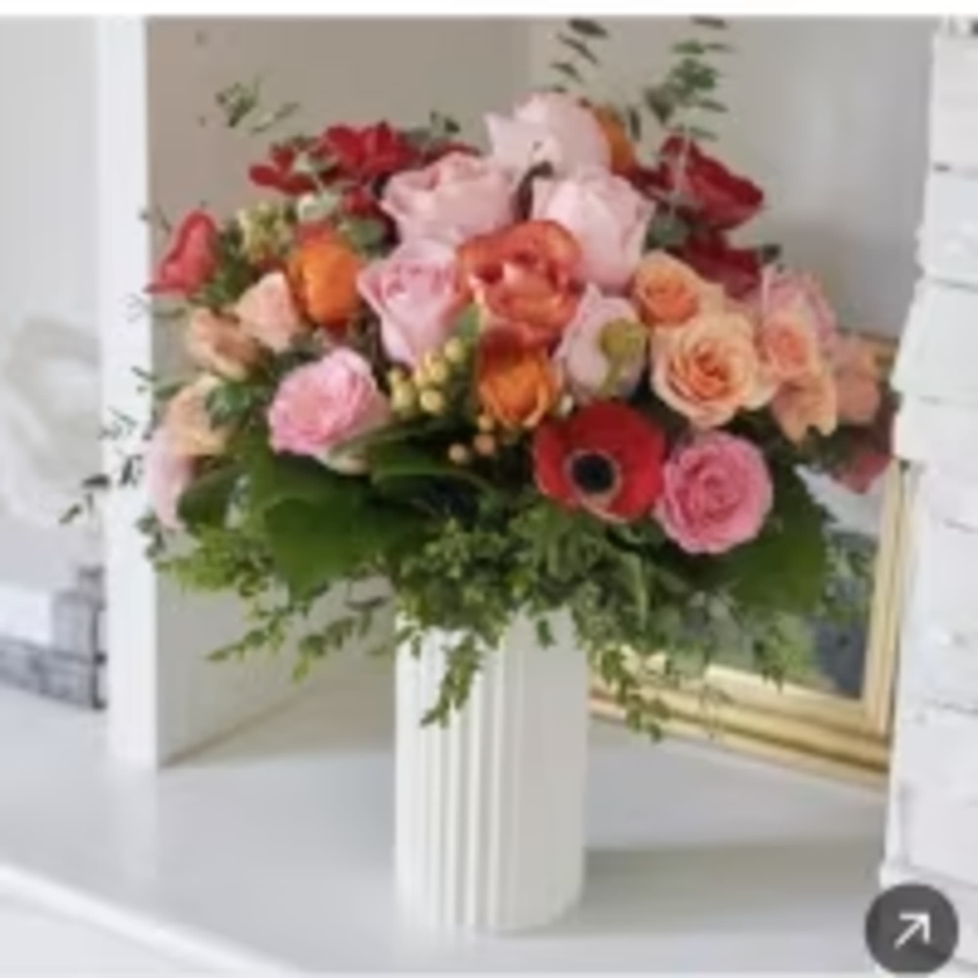 Combination of different colors of flowers in a gold vase