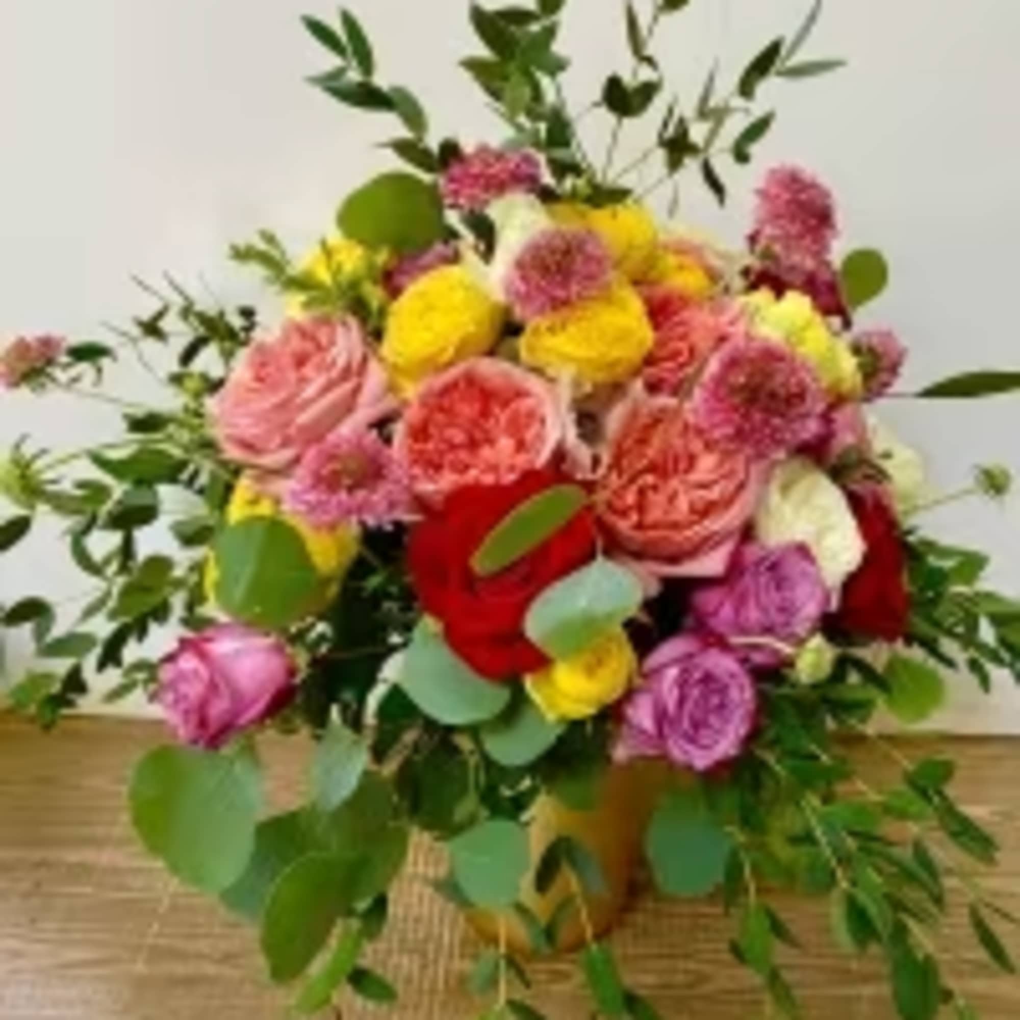Combination of different colors of flowers in a gold vase