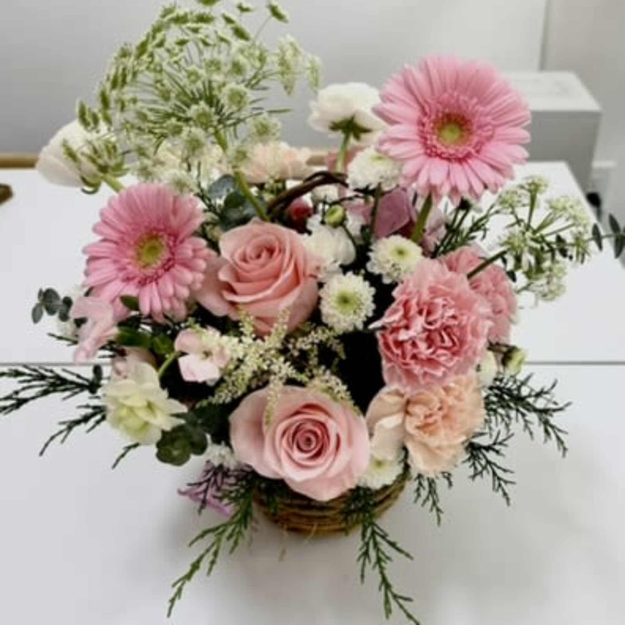 Soft pink gerbera daisies take center stage in this pink and white