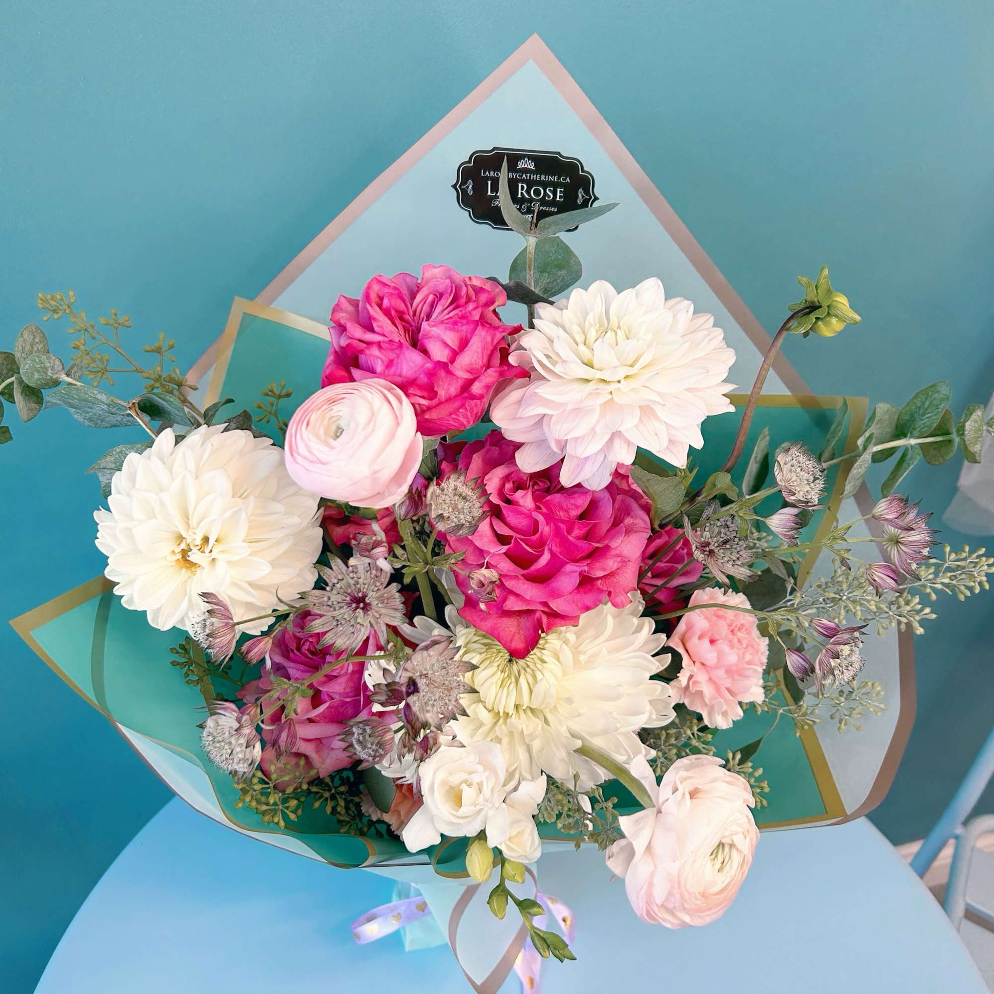 Bouquet of pink and white flowers wrapped in pastel paper
