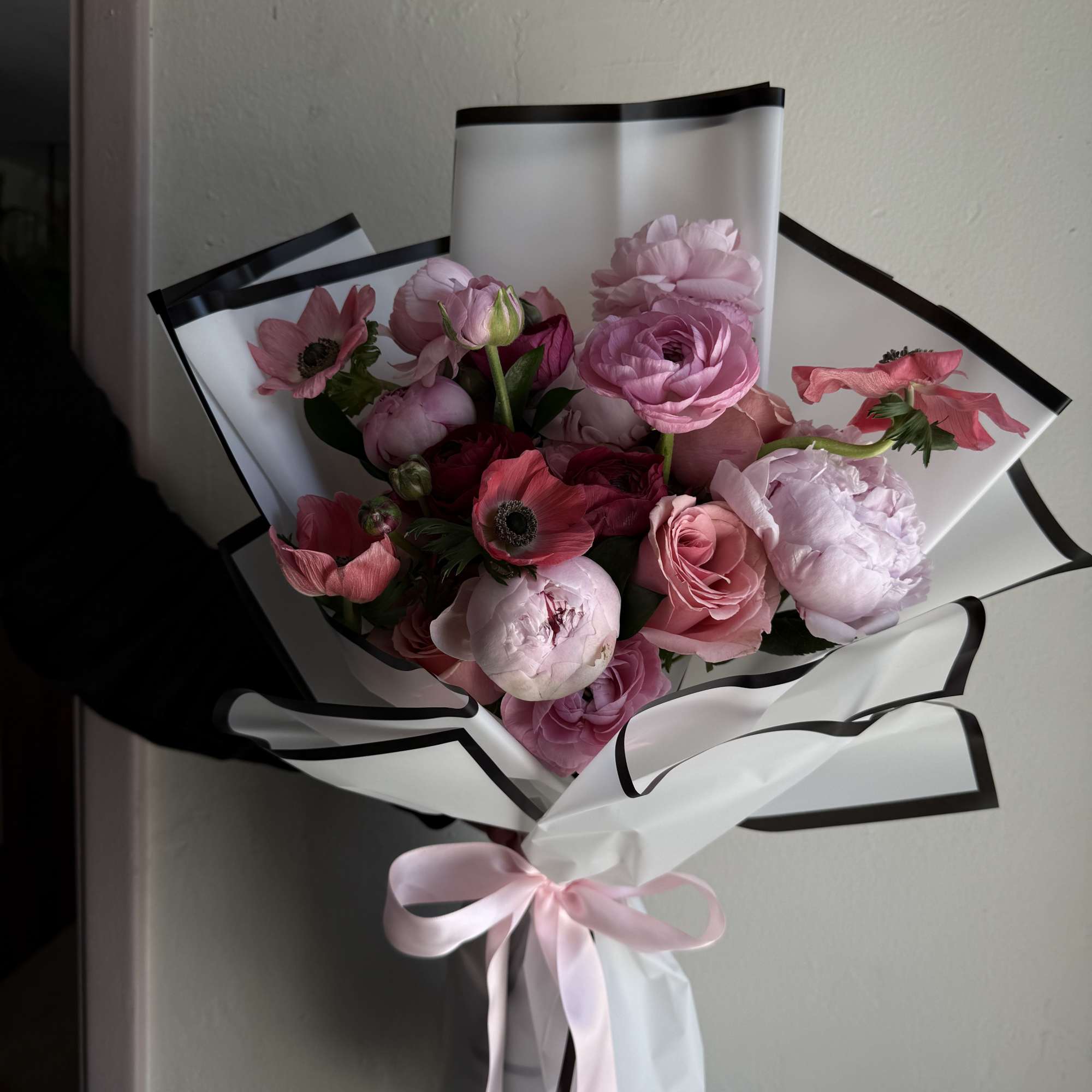 A garden-inspired bouquet featuring lush peonies, ranunculus, roses and anemones, arranged to