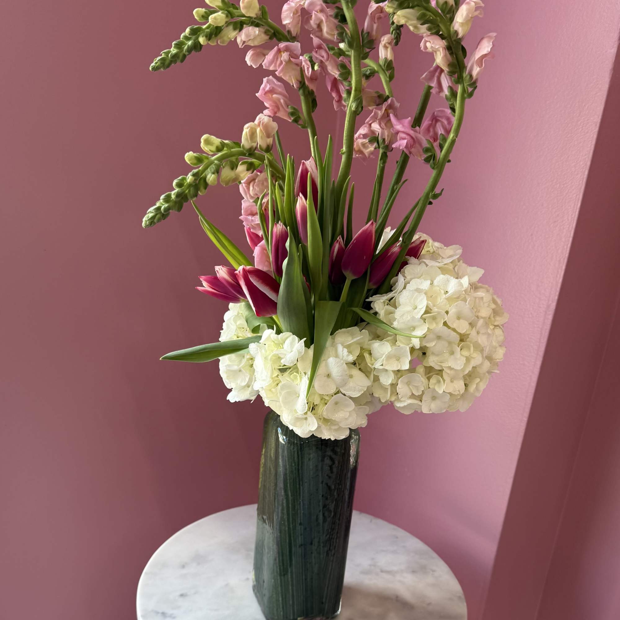Tall pink snapdragons give this floral arrangement a graceful vertical presence that