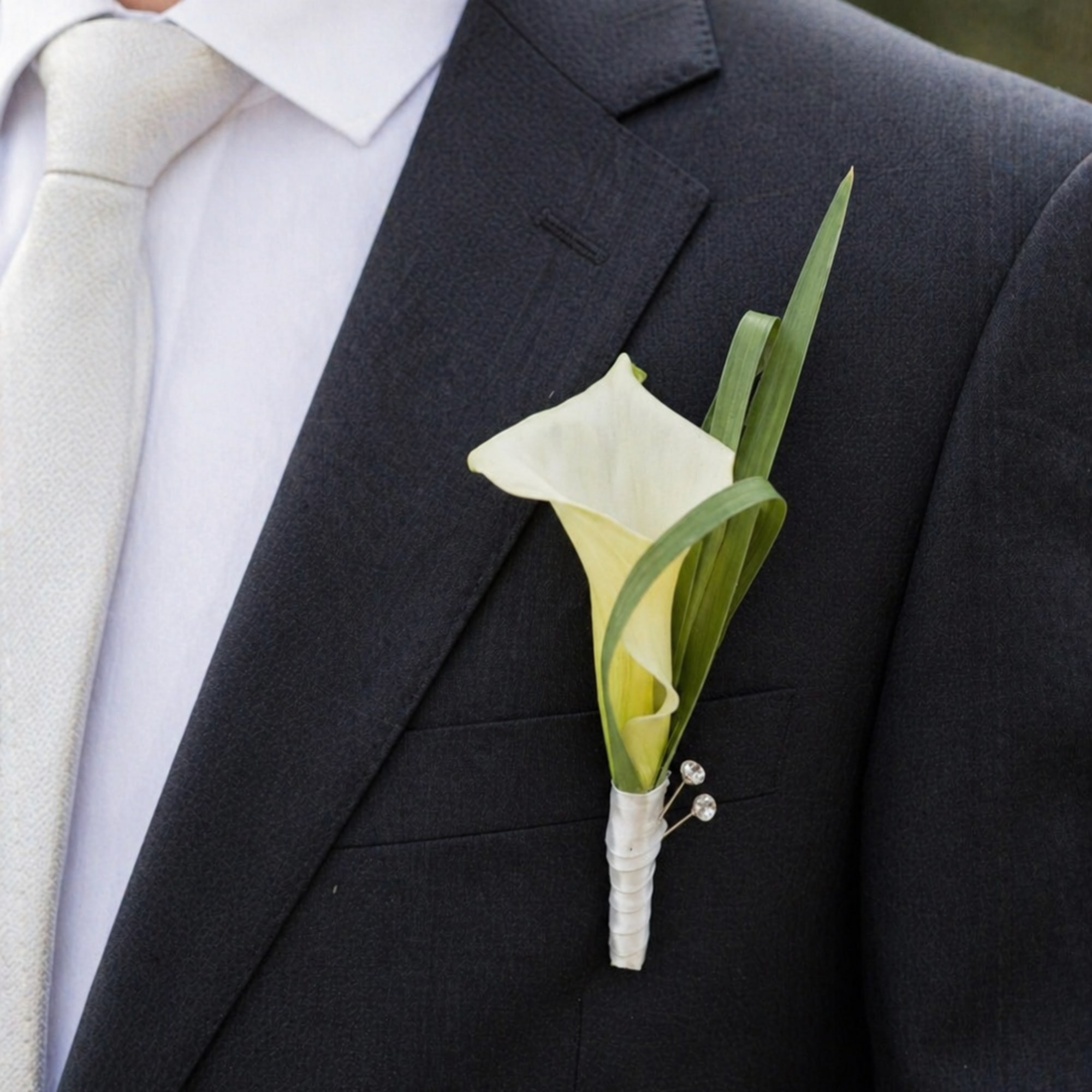 This elegant calla lily boutonniere is designed for a modern groom who