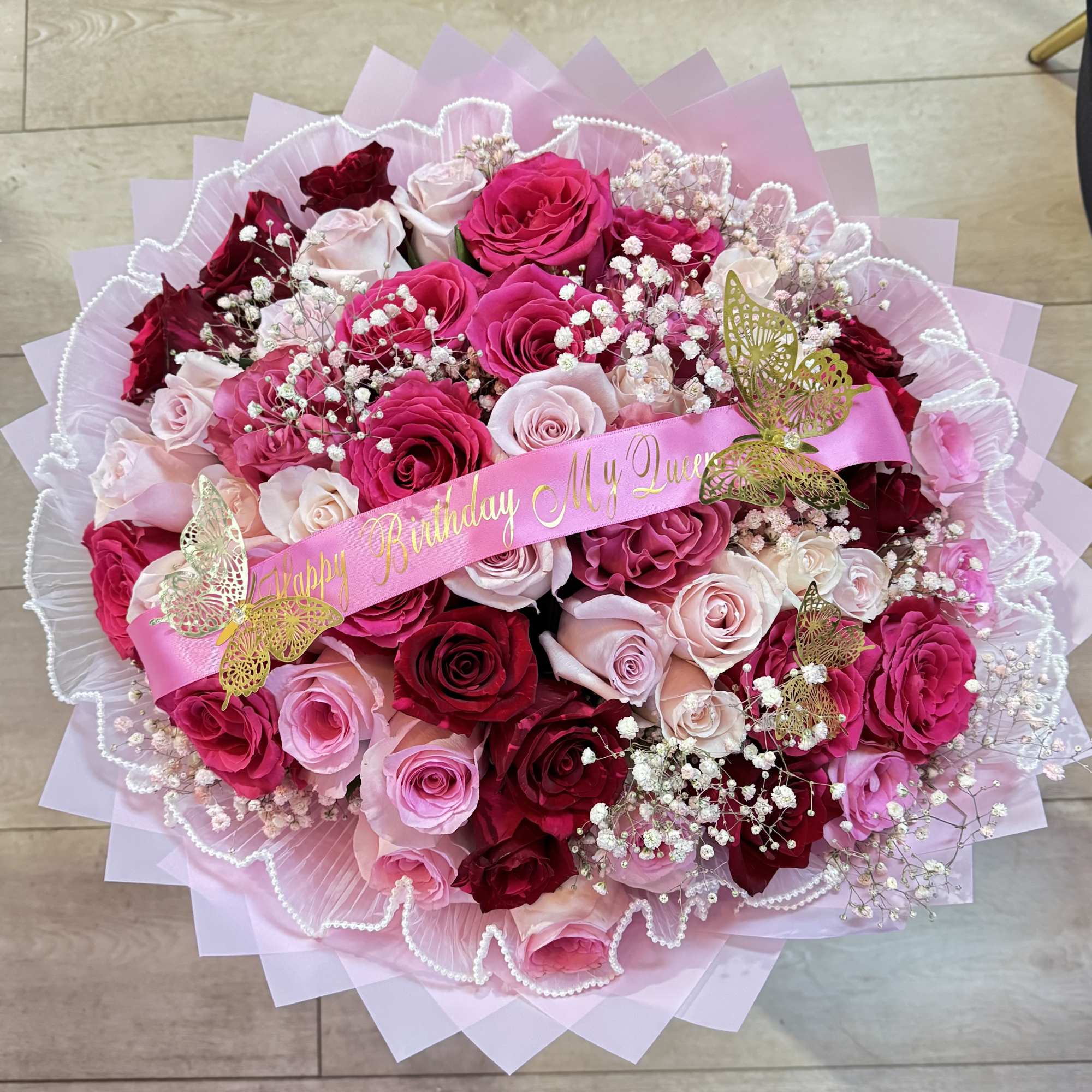 Pink and red rose bouquet with a birthday ribbon and butterfly decorations
