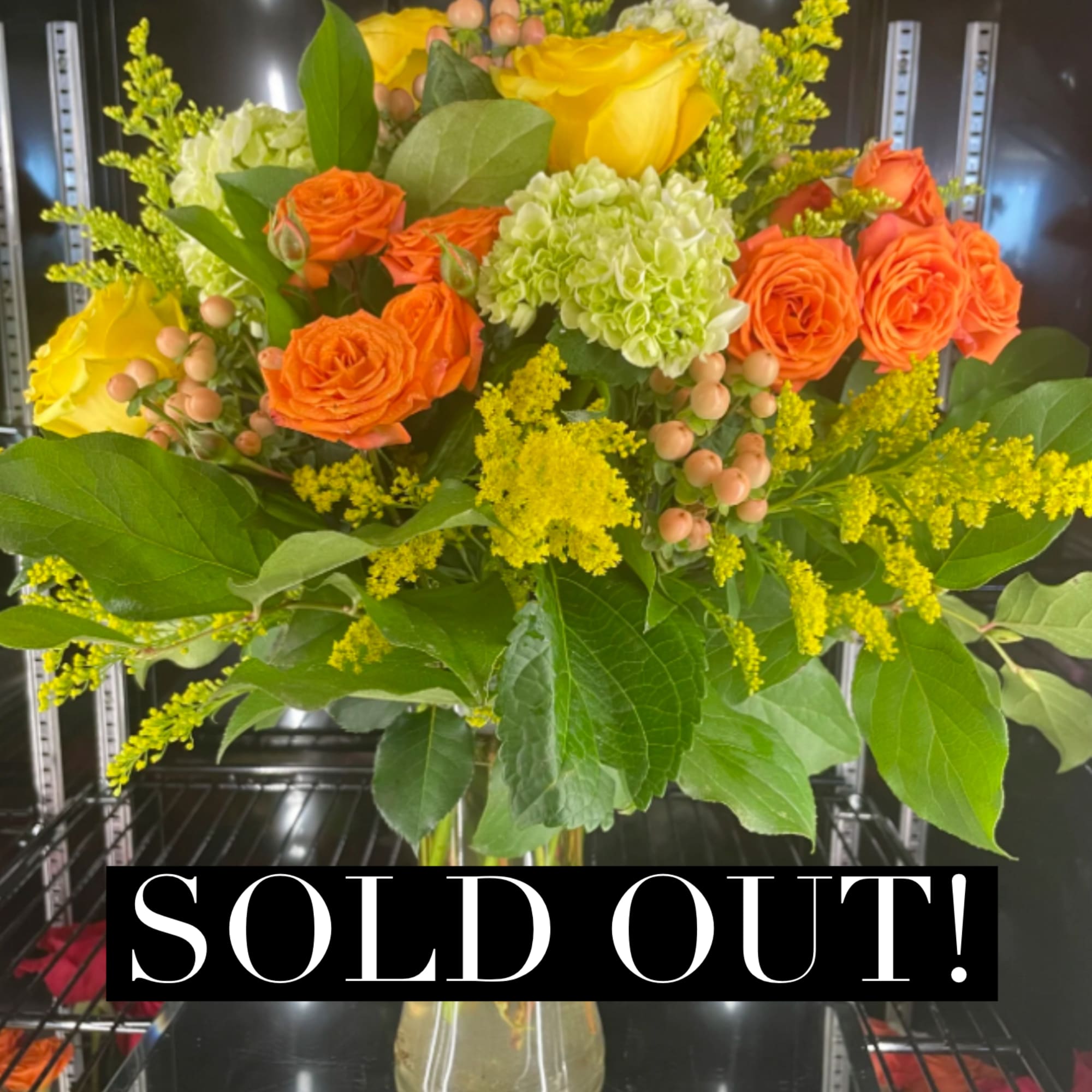 Bouquet of yellow and orange roses in a clear glass vase