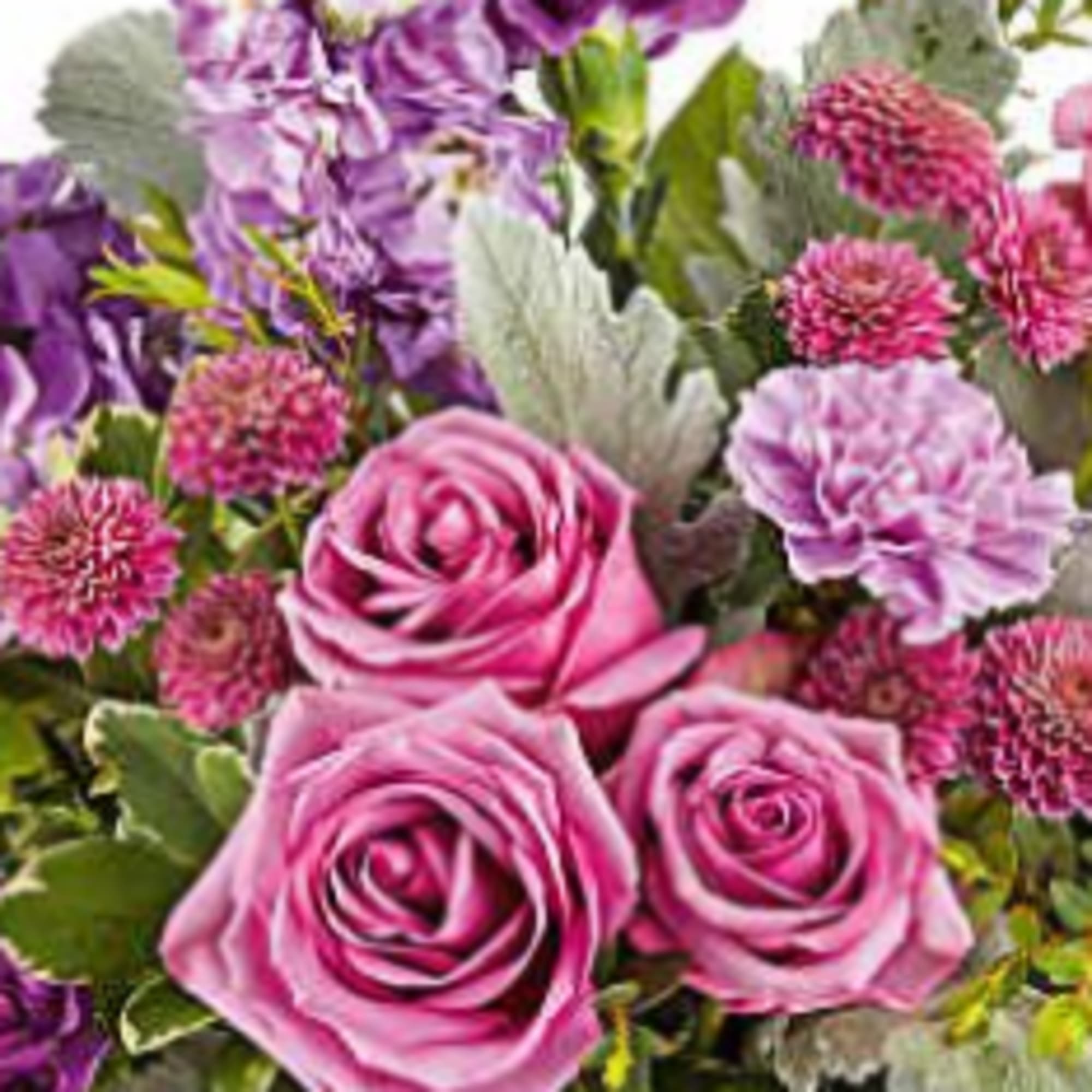 Assorted fresh cut flowers in a wicker basket beautifully arranged.  
Colors