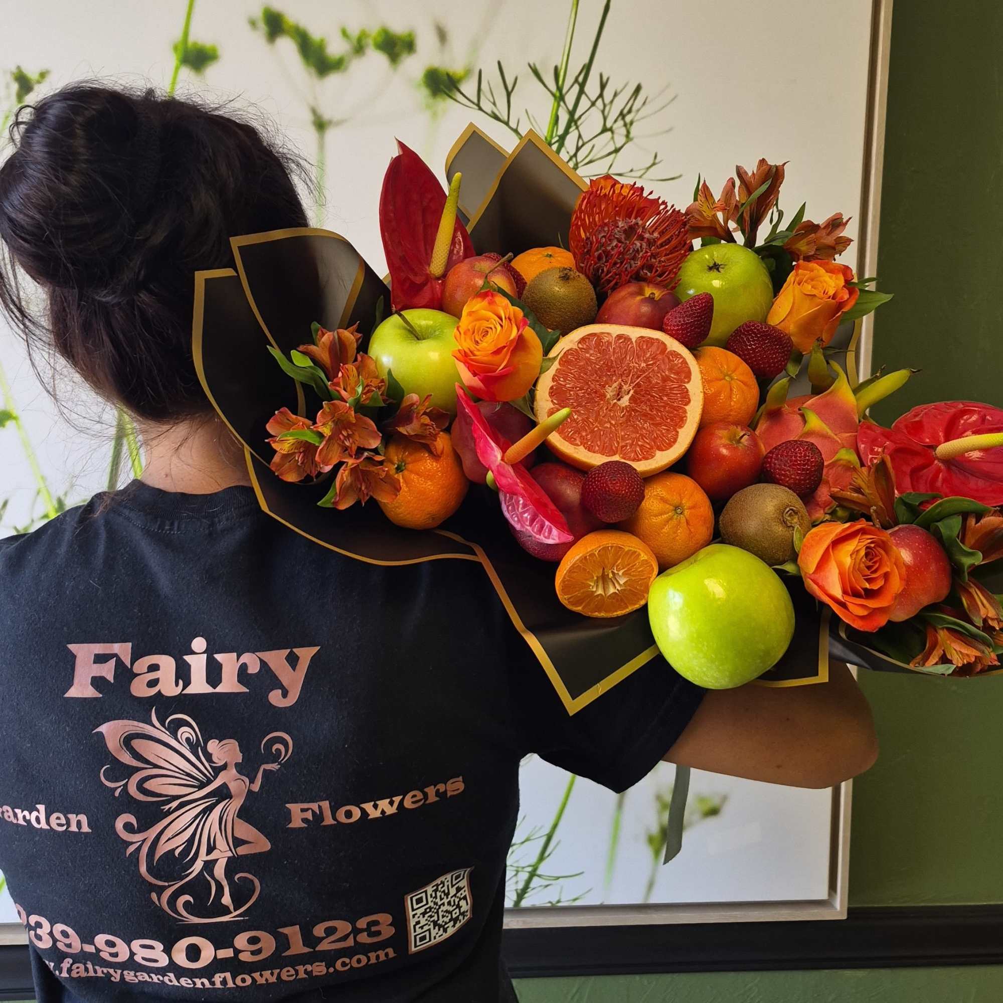 Vivid red anthuriums and petite orange roses create a bold, celebratory bouquet