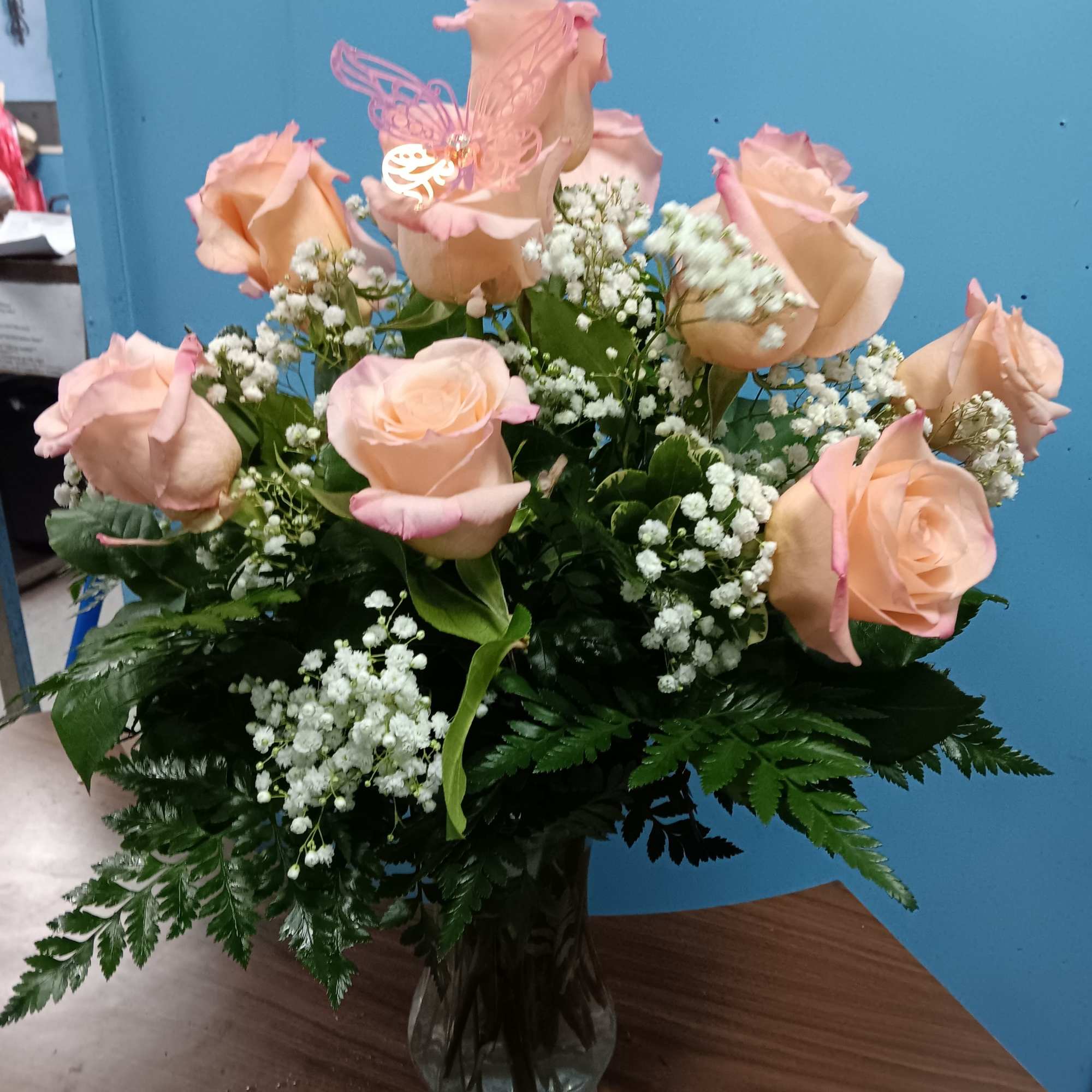 Soft peach-pink roses gathered in a rounded, upright bouquet create a tender