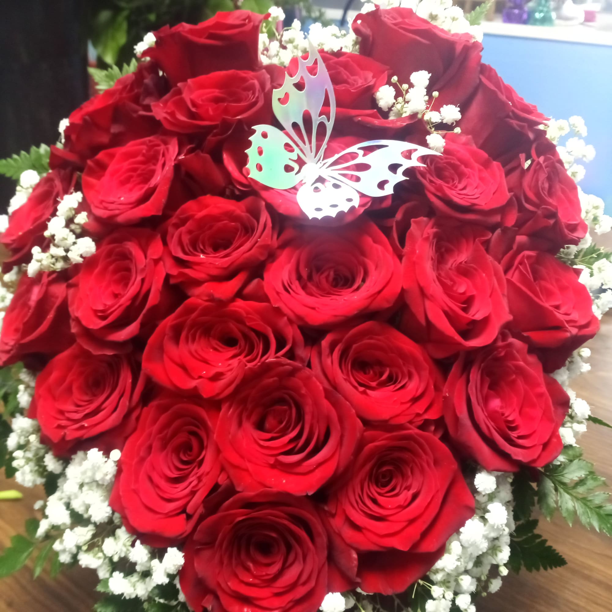 Bouquet of red roses with white baby's breath and a butterfly pick