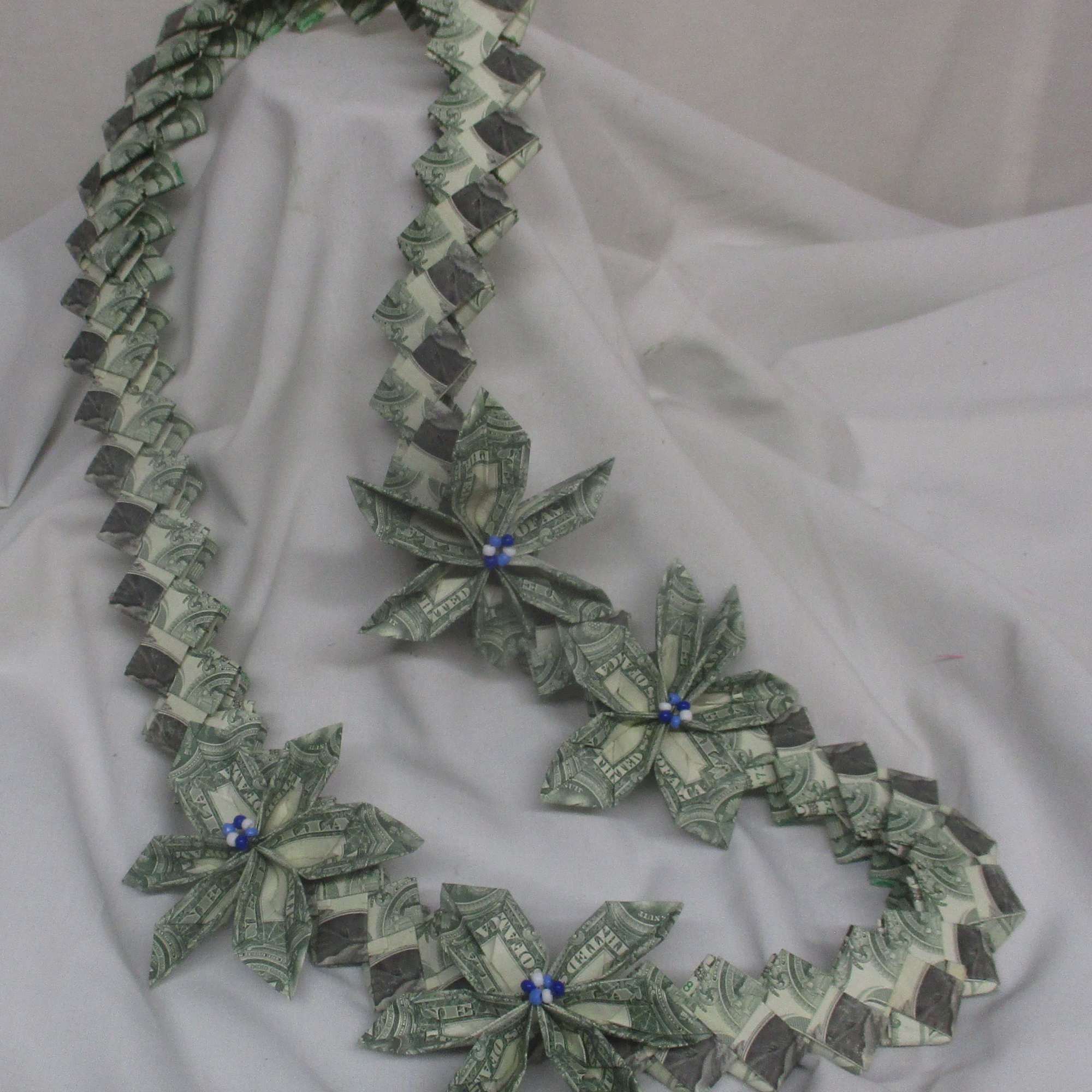 A bold, celebratory twist on a traditional gift-this green-and-white money lei turns