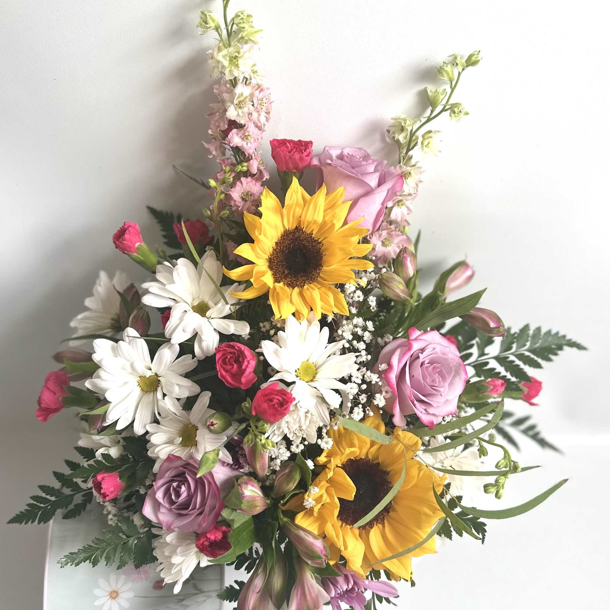 Bright sunflowers with lavender roses, daisies and mixed blooms with a wildflower