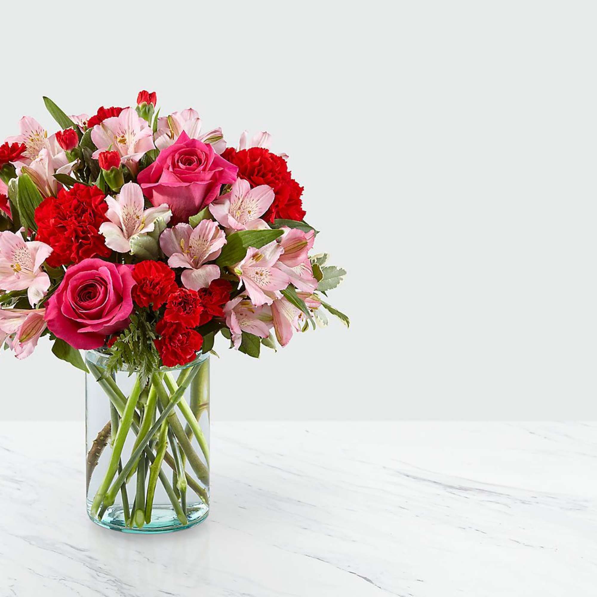 Blushing shades of pink blooms are nestled in lush greens to charm