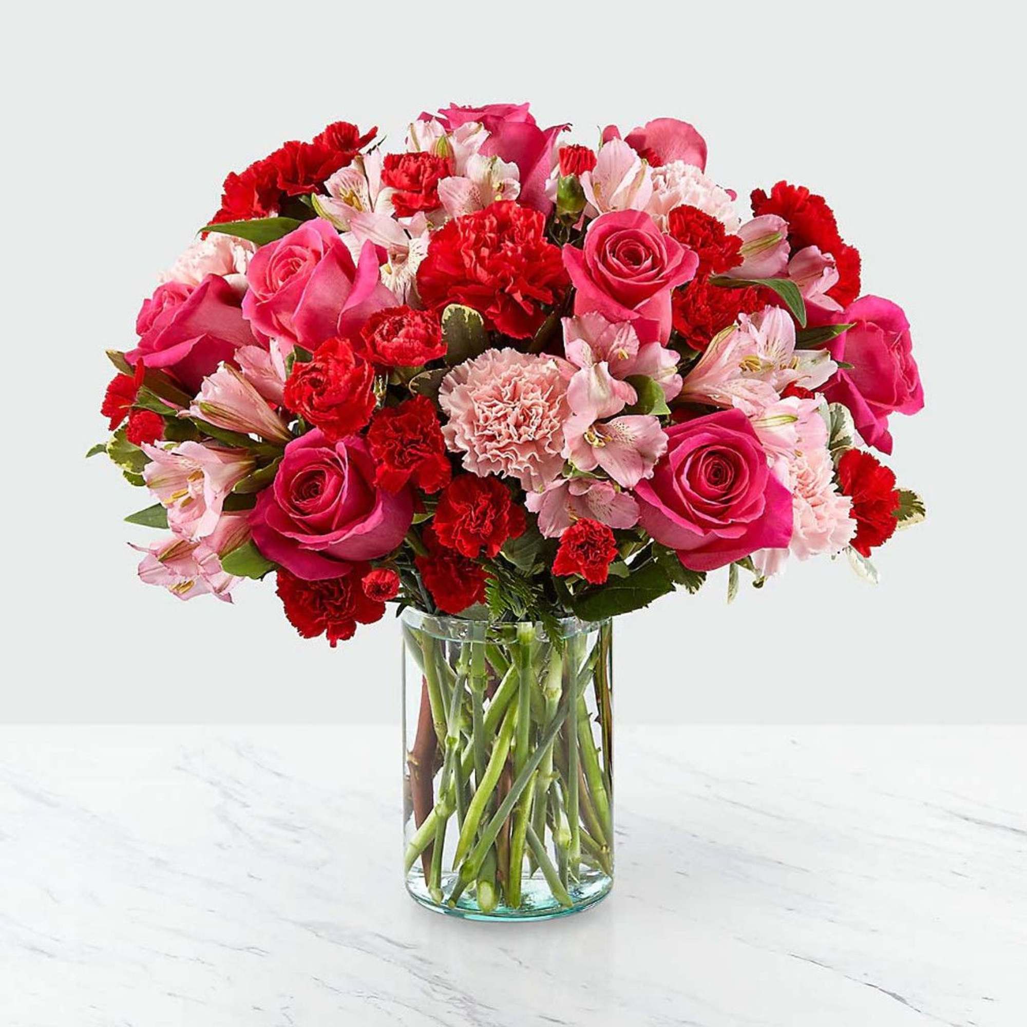 Blushing shades of pink blooms are nestled in lush greens to charm