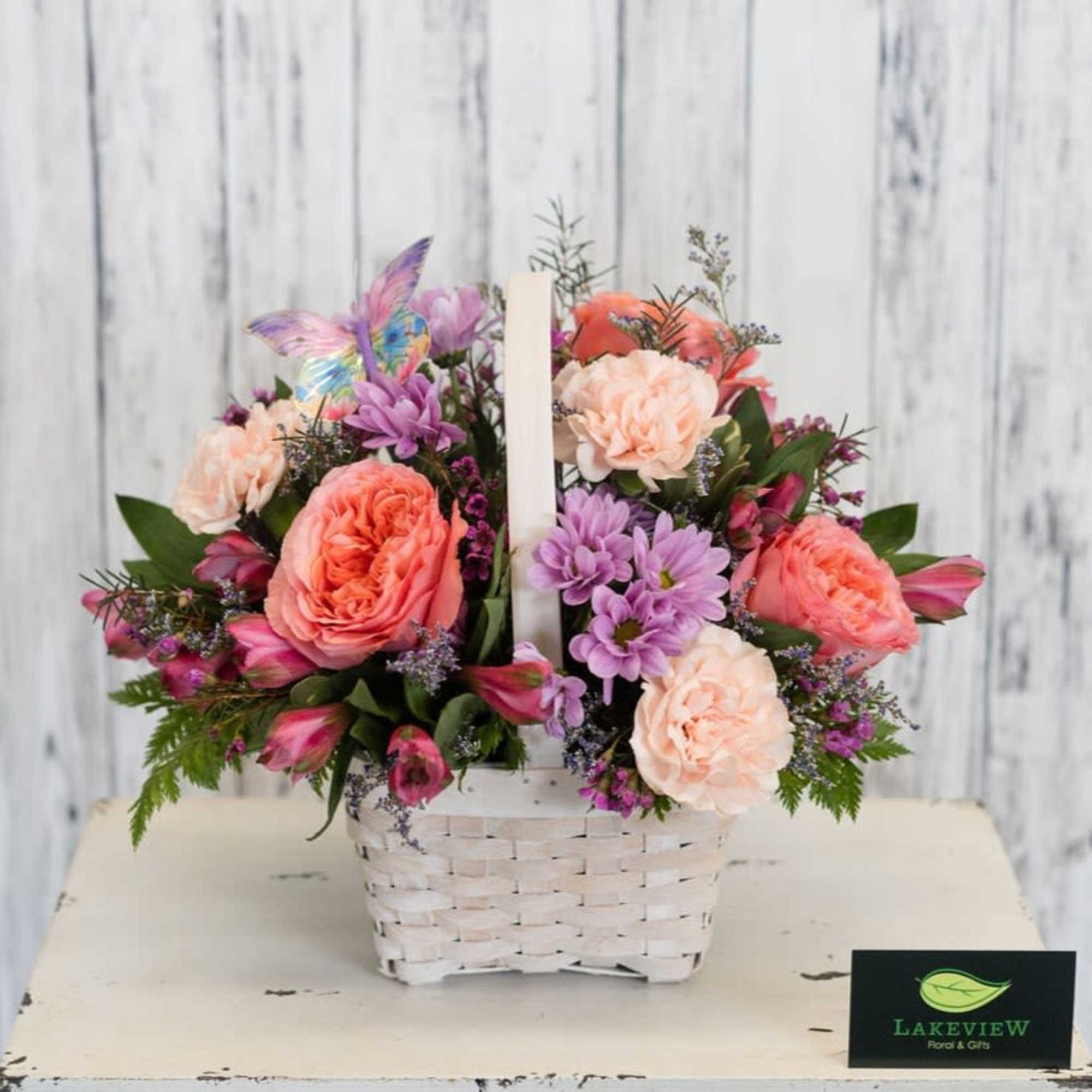 Soft peach, pink and lavender blooms spill from a white woven basket