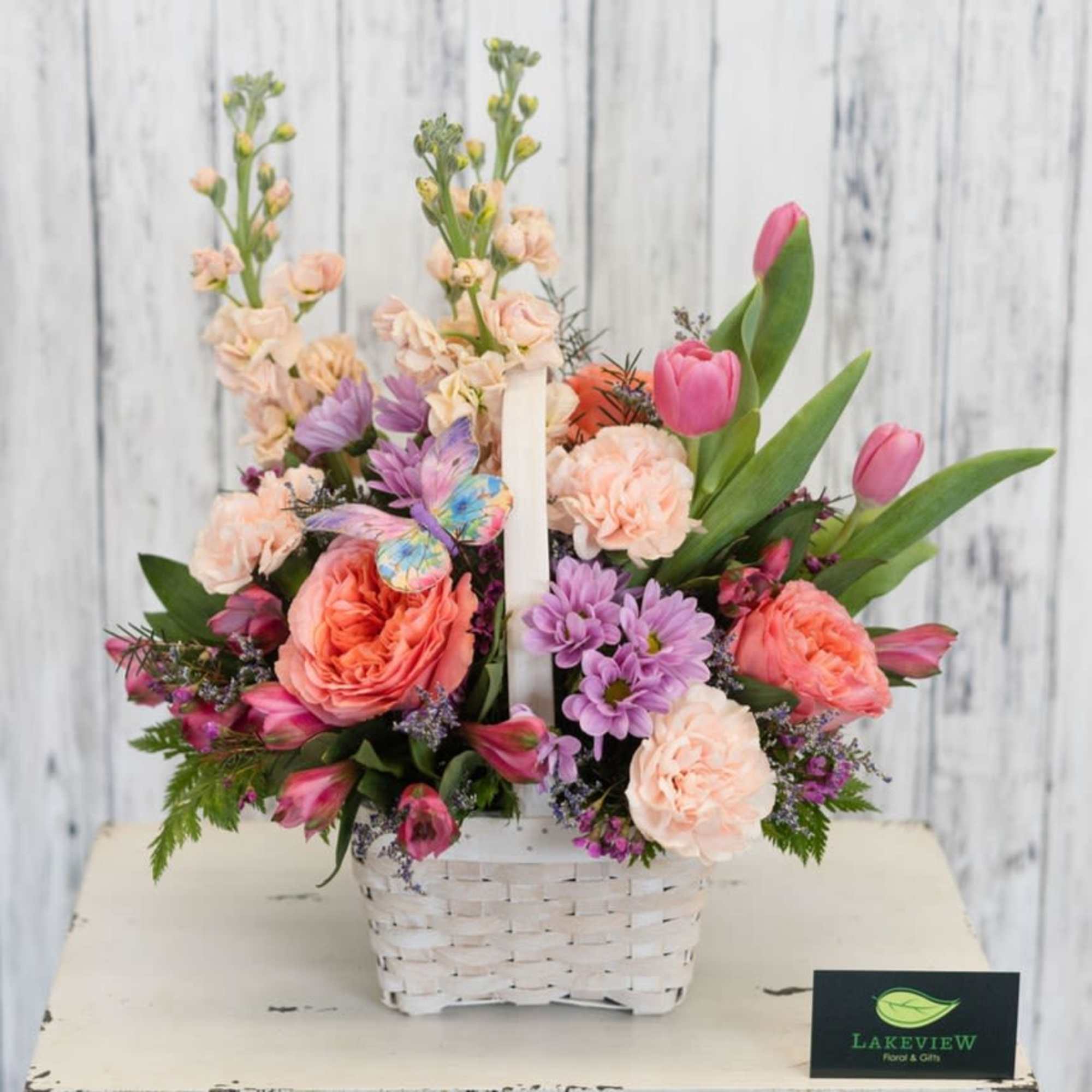 Soft peach, pink and lavender blooms spill from a white woven basket