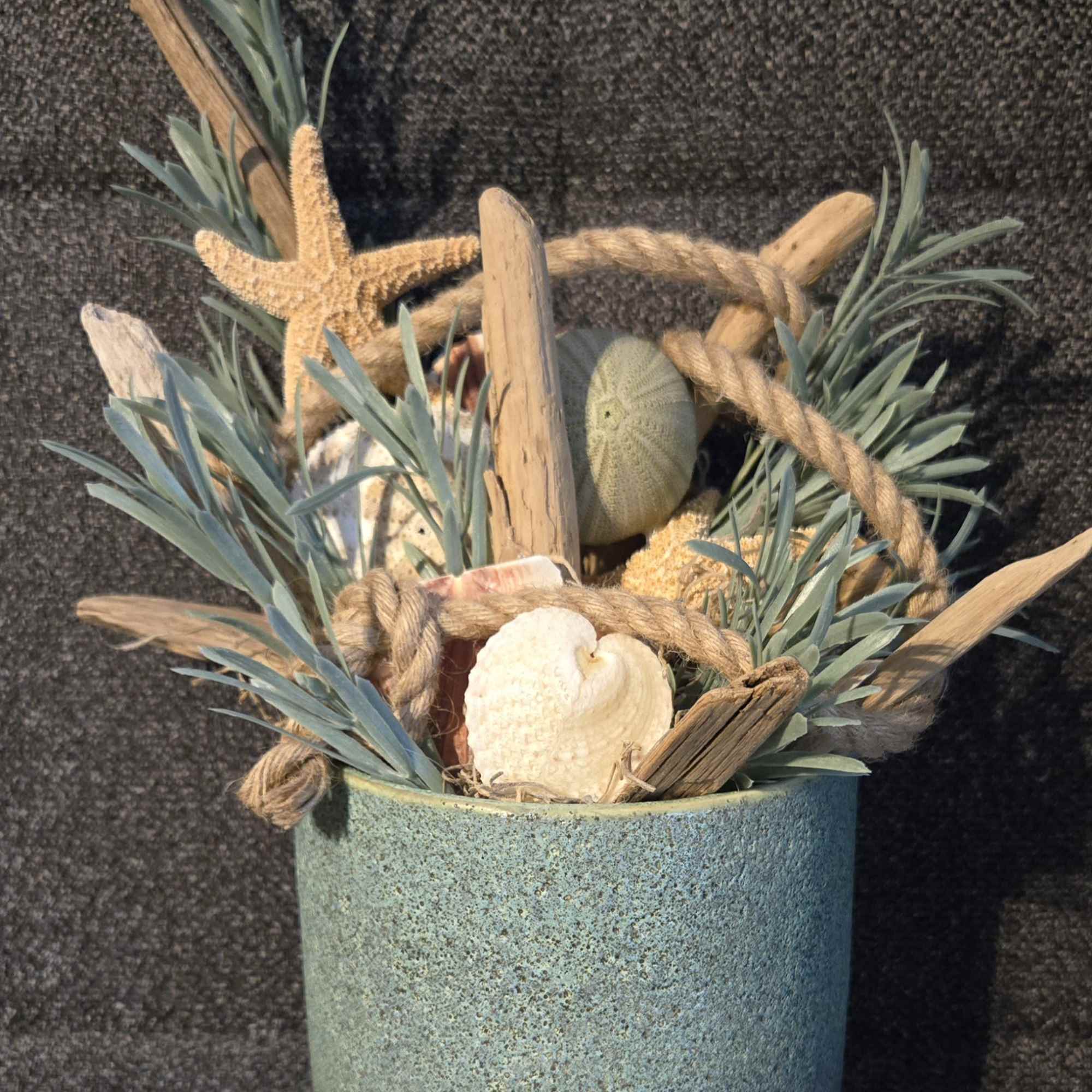 Coastal-themed pot filled with driftwood, shells, starfish decor and rope