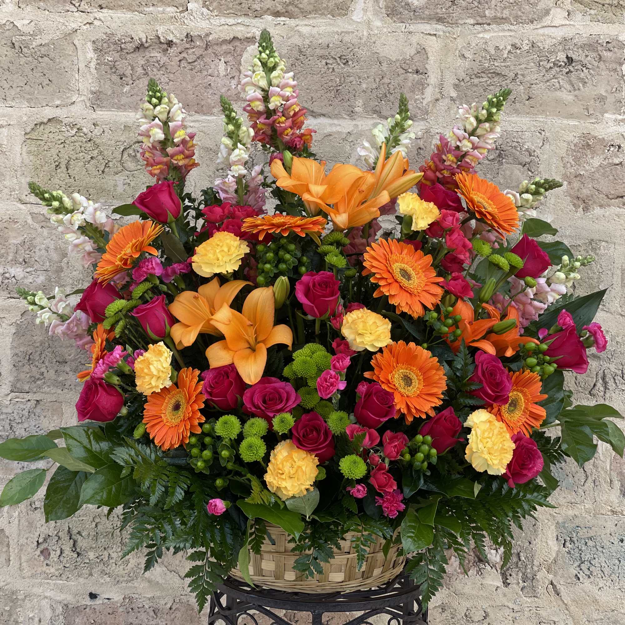 Basket arrangement of orange lilies, pink roses, and gerbera daisies
