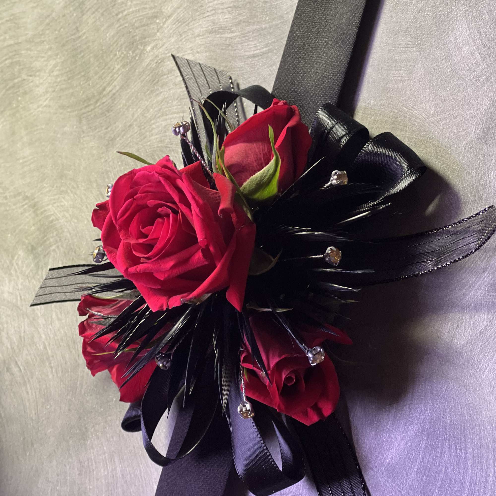 Small corsage with red roses and black ribbon