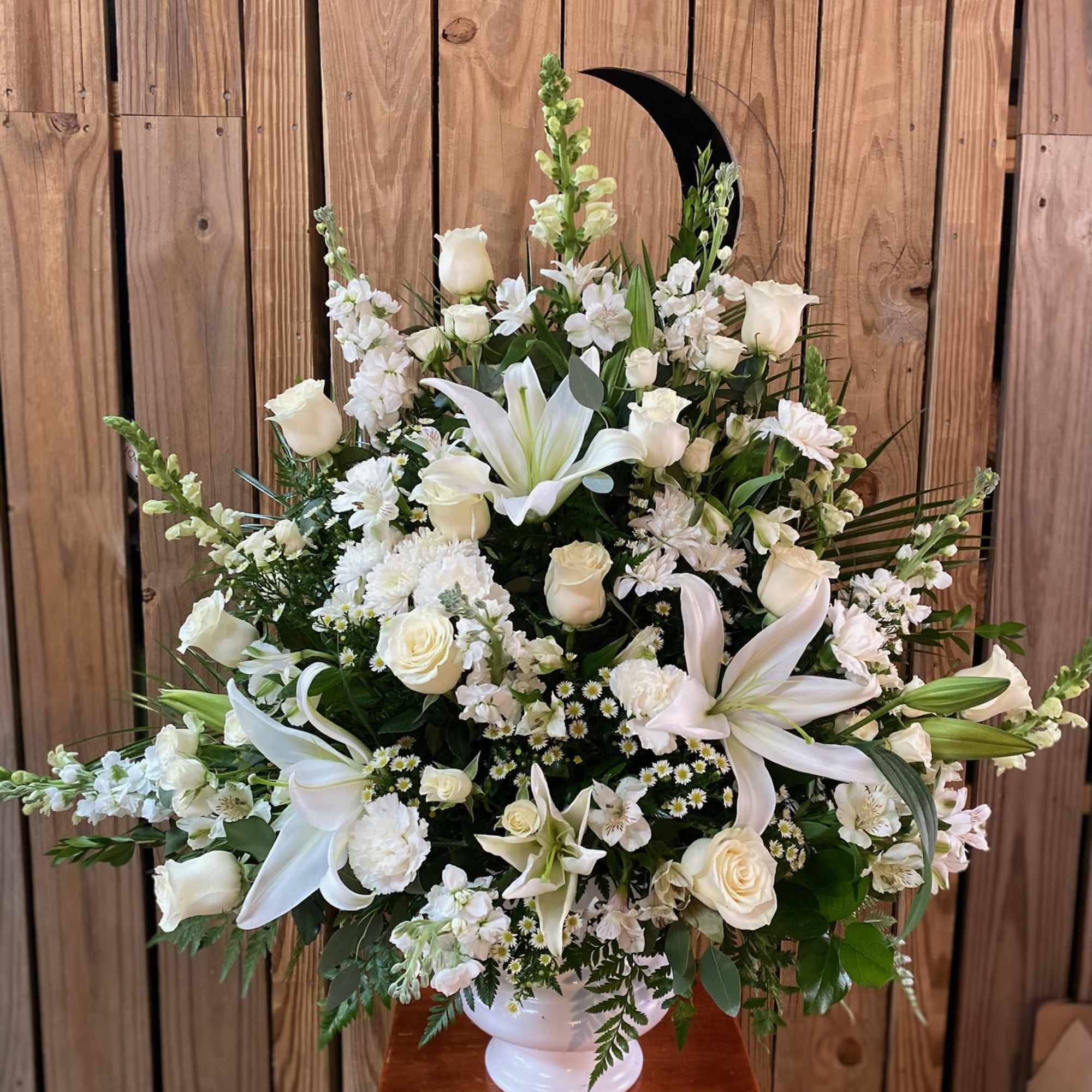 White floral arrangement in a white pedestal vase